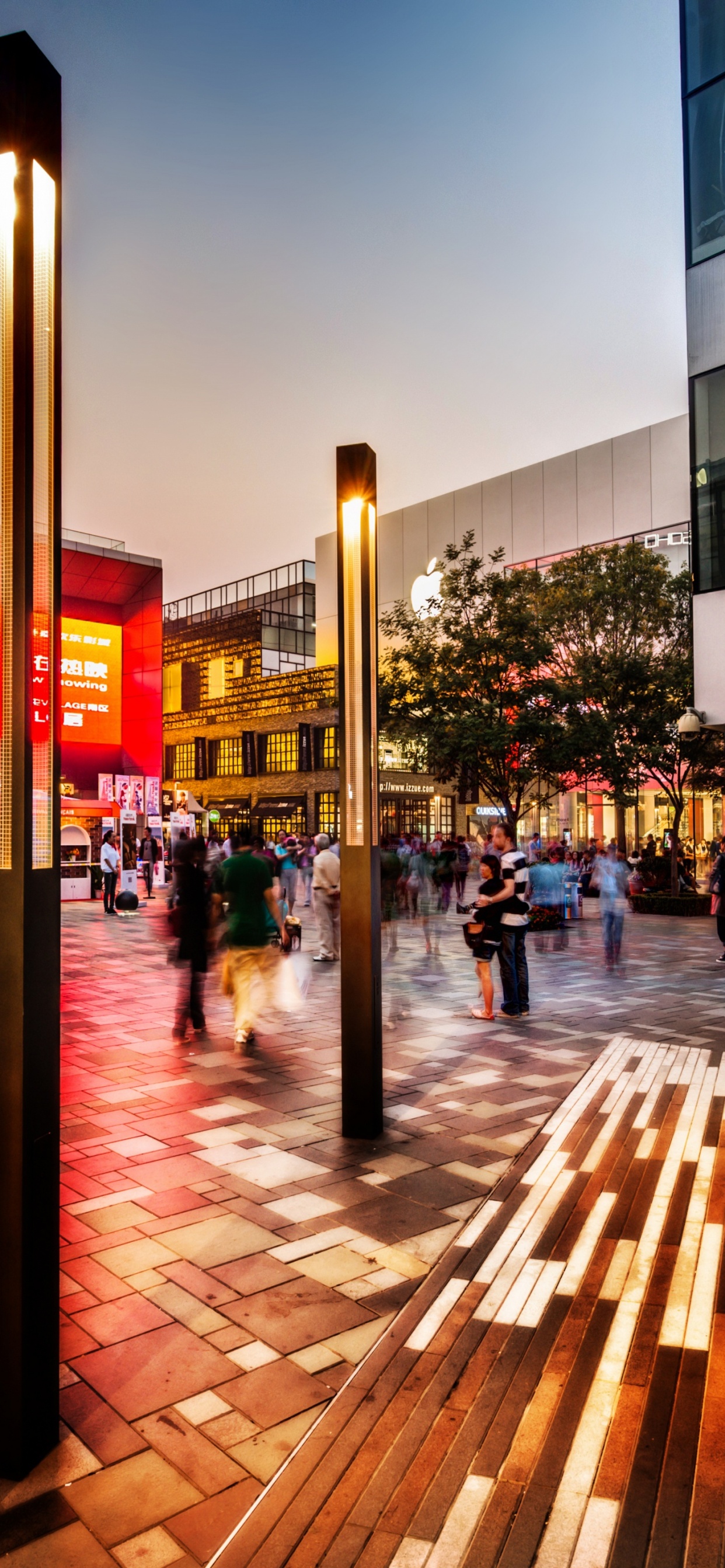 Leute, Die Nachts Auf Dem Bürgersteig in Der Nähe Des Gebäudes Gehen. Wallpaper in 1242x2688 Resolution