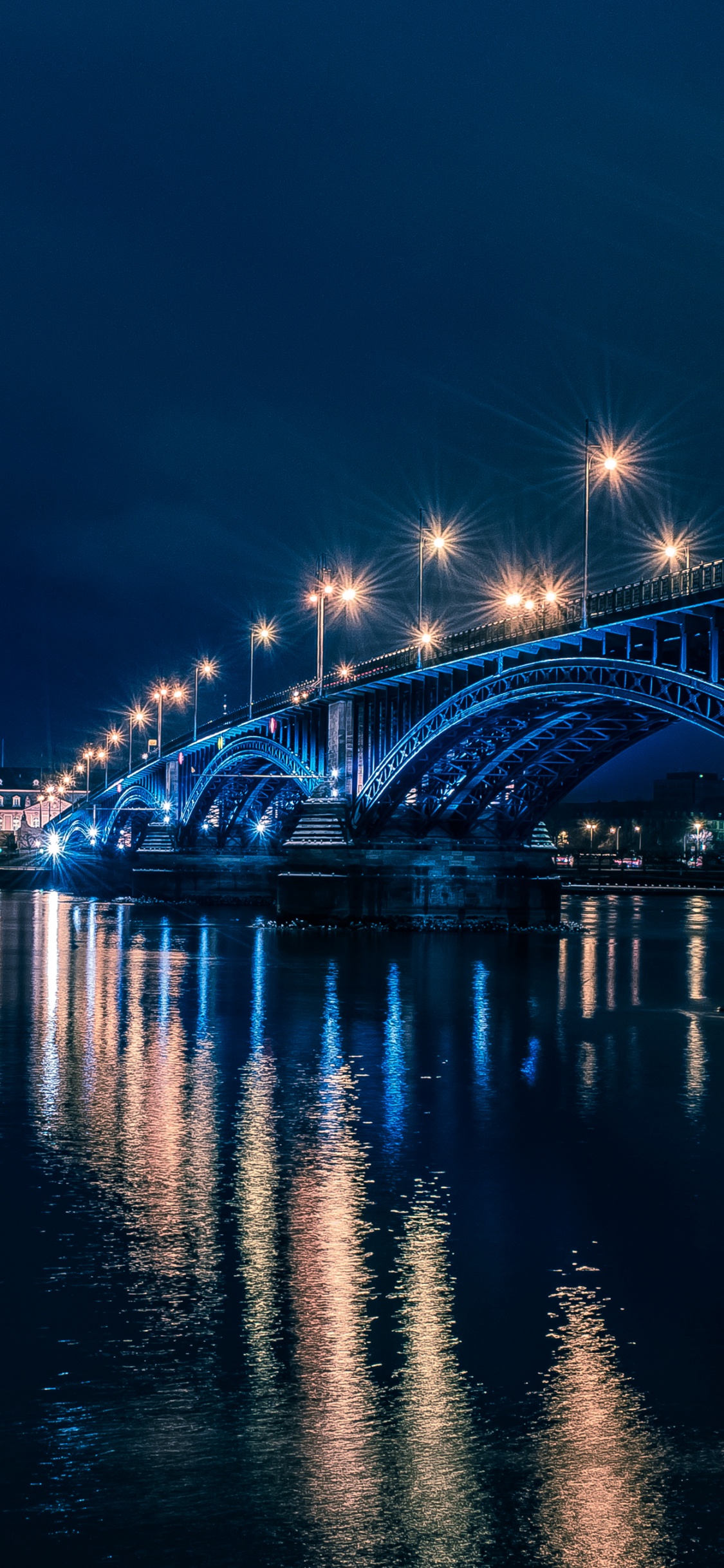 Brücke Über Wasser Während Der Nacht Night. Wallpaper in 1125x2436 Resolution