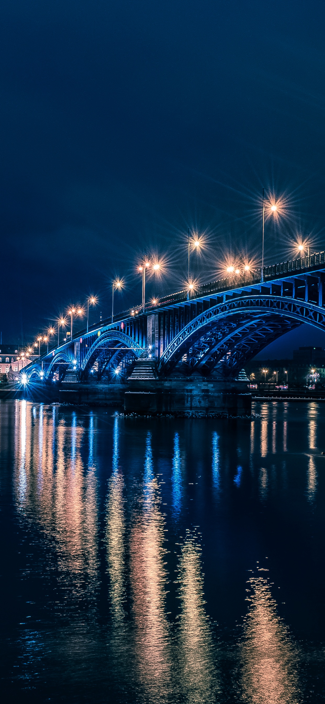 Bridge Over Water During Night Time. Wallpaper in 1242x2688 Resolution