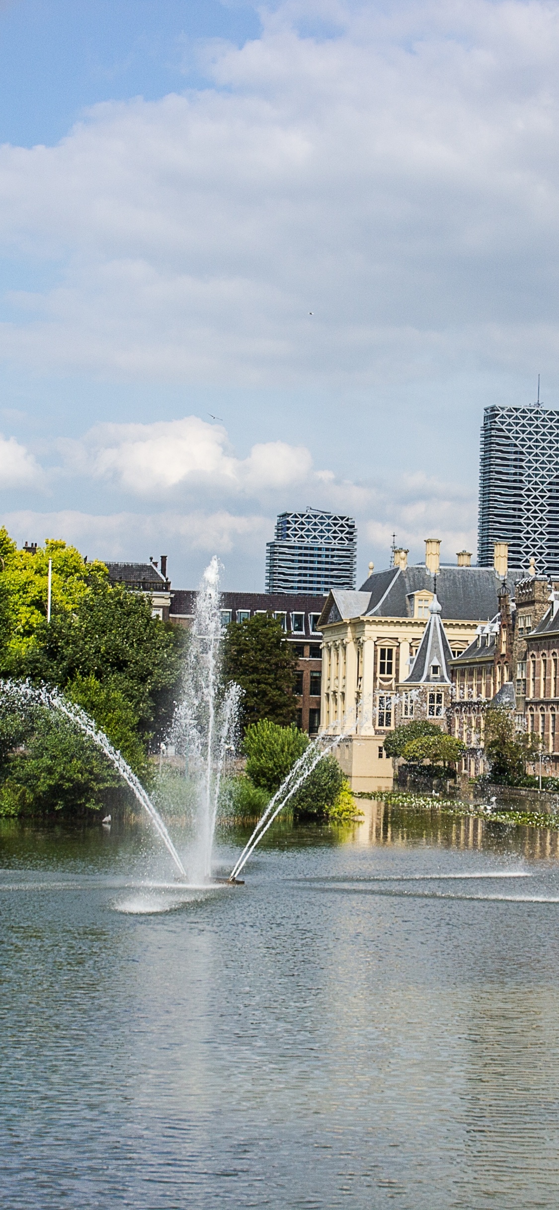 Water Fountain in The Middle of City Buildings During Daytime. Wallpaper in 1125x2436 Resolution