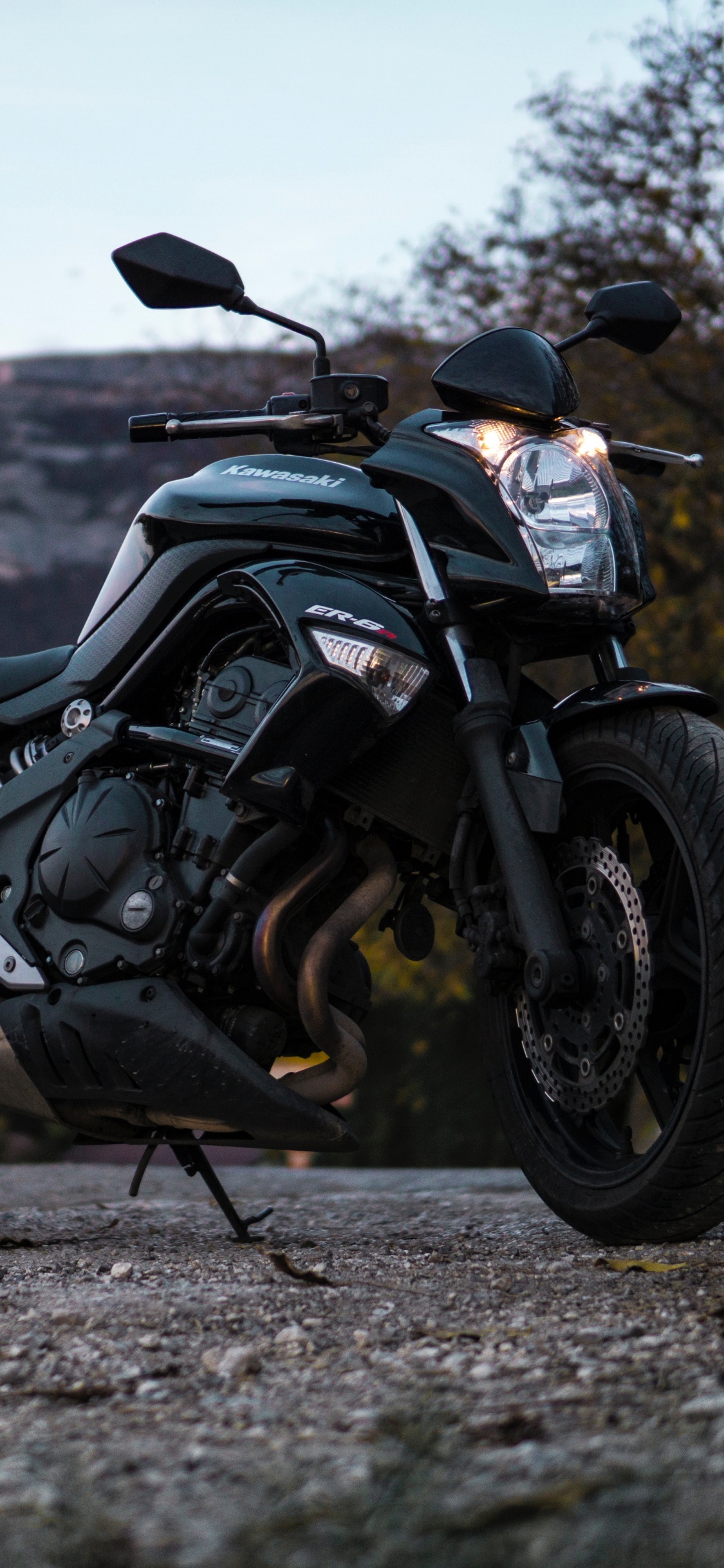 Motocicleta Negra y Gris en Camino de Tierra Durante el Día. Wallpaper in 1125x2436 Resolution