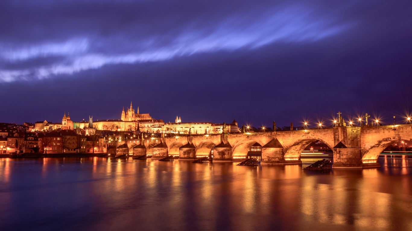 Brown Concrete Building Near Body of Water During Night Time. Wallpaper in 1366x768 Resolution