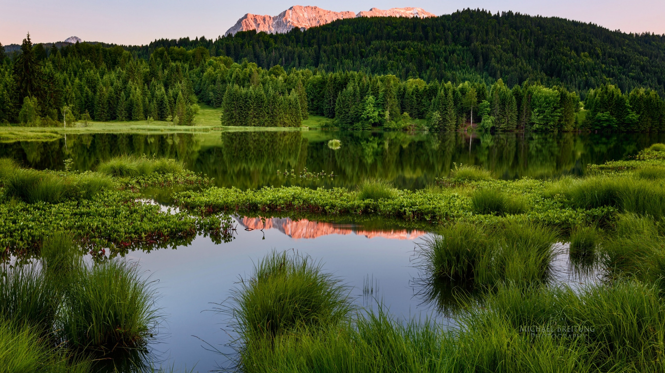 Green Grass Near Lake and Mountain During Daytime. Wallpaper in 1366x768 Resolution
