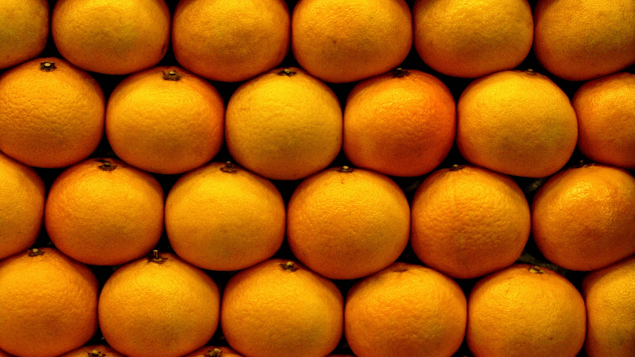 Frutos Redondos Amarillos Sobre Superficie Blanca. Wallpaper in 1280x720 Resolution