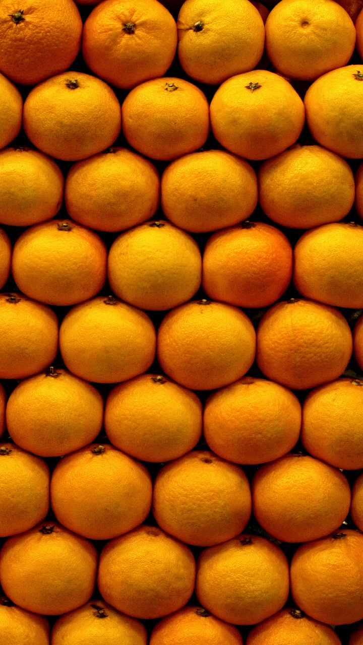 Frutos Redondos Amarillos Sobre Superficie Blanca. Wallpaper in 720x1280 Resolution