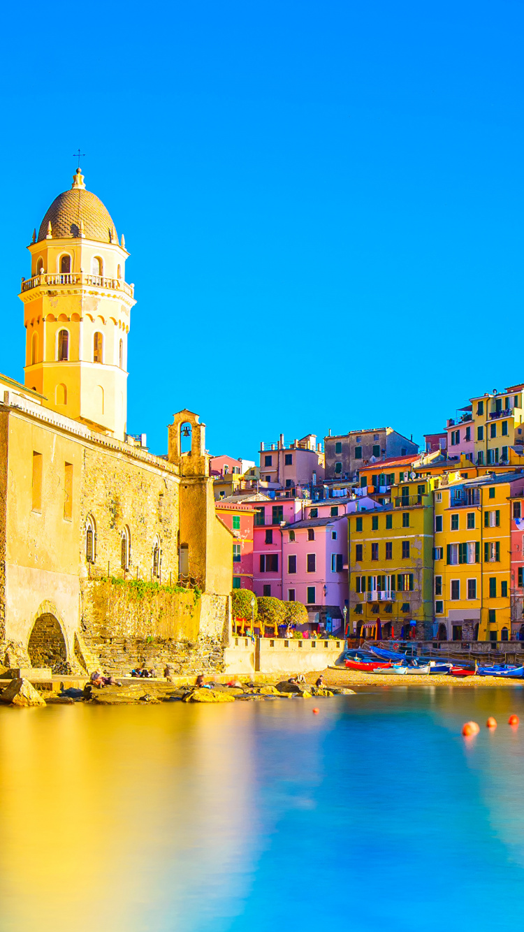 Brown Concrete Building Beside Body of Water During Daytime. Wallpaper in 750x1334 Resolution