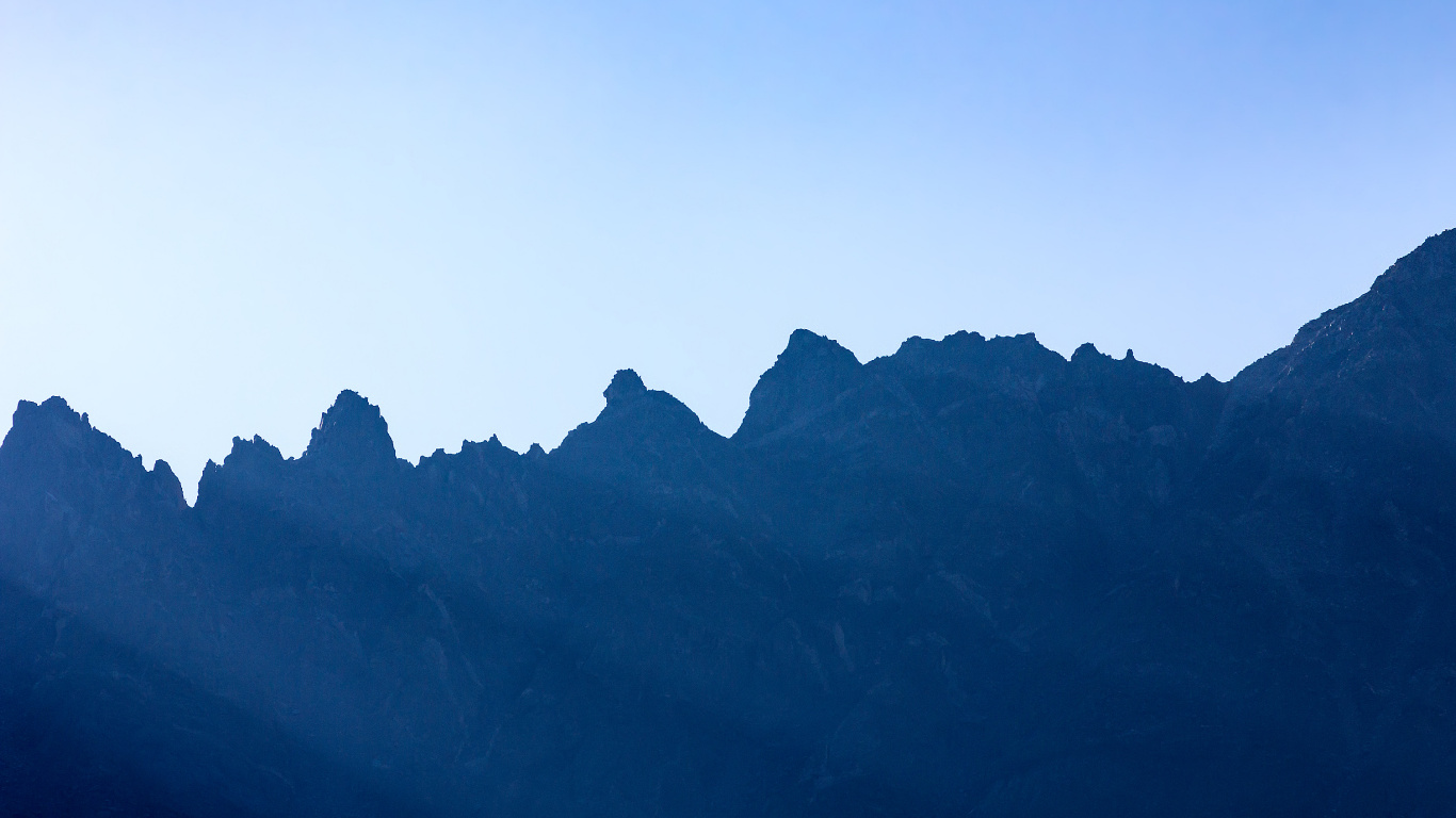 Tagsüber Schwarze Berge Unter Blauem Himmel. Wallpaper in 1366x768 Resolution