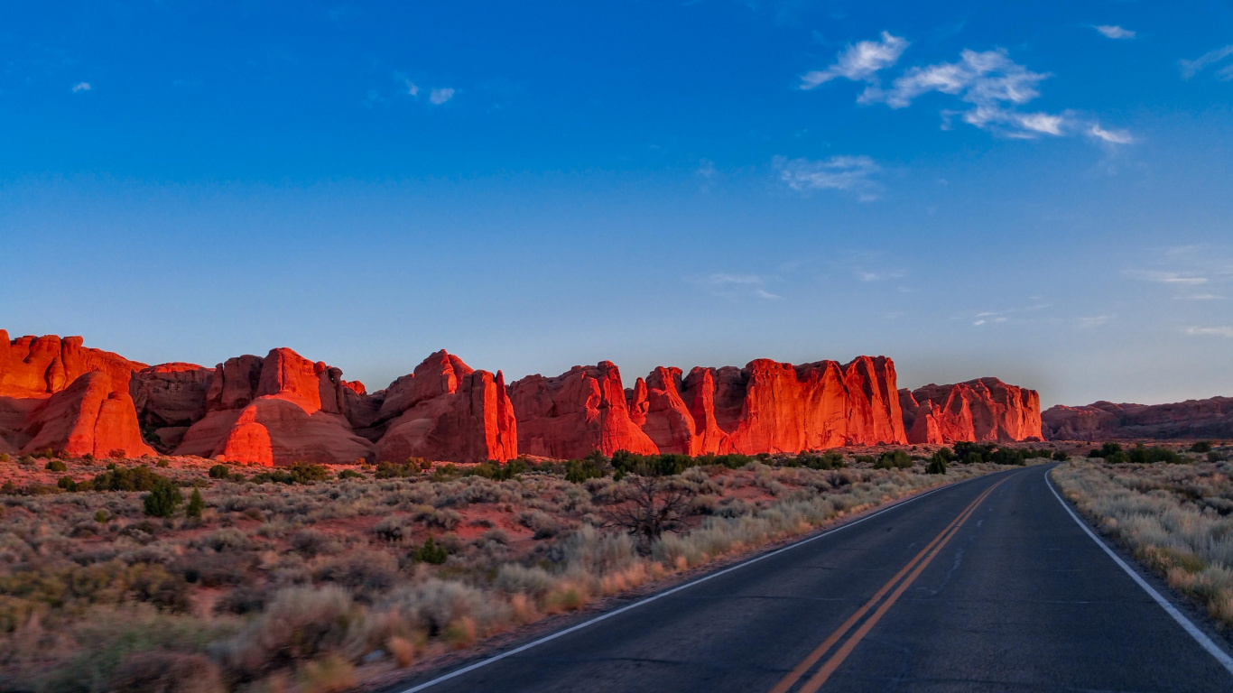 Route Asphaltée Grise Entre Brown Rock Formation Sous Ciel Bleu Pendant la Journée. Wallpaper in 1366x768 Resolution