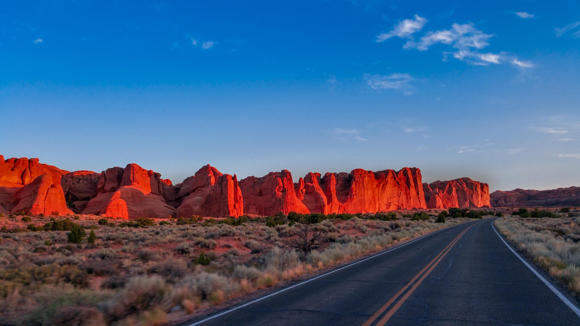 Route Asphaltée Grise Entre Brown Rock Formation Sous Ciel Bleu Pendant la Journée. Wallpaper in 1920x1080 Resolution