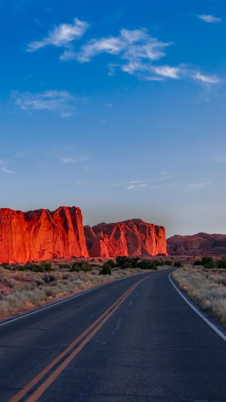 Route Asphaltée Grise Entre Brown Rock Formation Sous Ciel Bleu Pendant la Journée. Wallpaper in 720x1280 Resolution