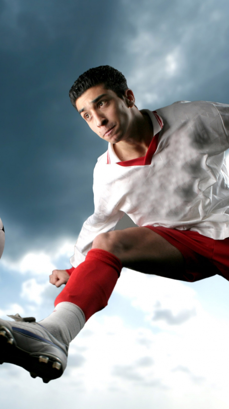 Homme en Chemise Blanche et Short Rouge Jouant au Football. Wallpaper in 750x1334 Resolution