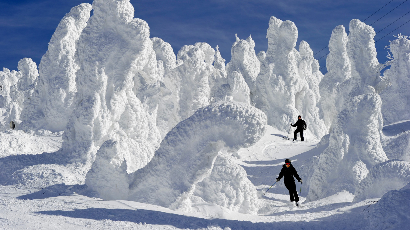 2 Persona de Pie Sobre un Terreno Cubierto de Nieve Cerca de la Montaña Cubierta de Nieve Durante el Día. Wallpaper in 1366x768 Resolution