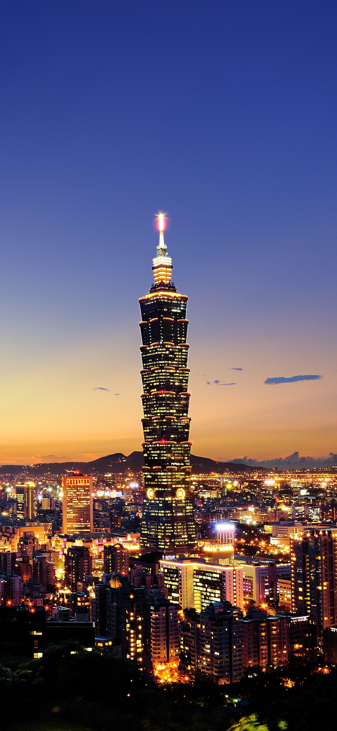 Ciudad Con Edificios de Gran Altura Durante la Noche.. Wallpaper in 1125x2436 Resolution