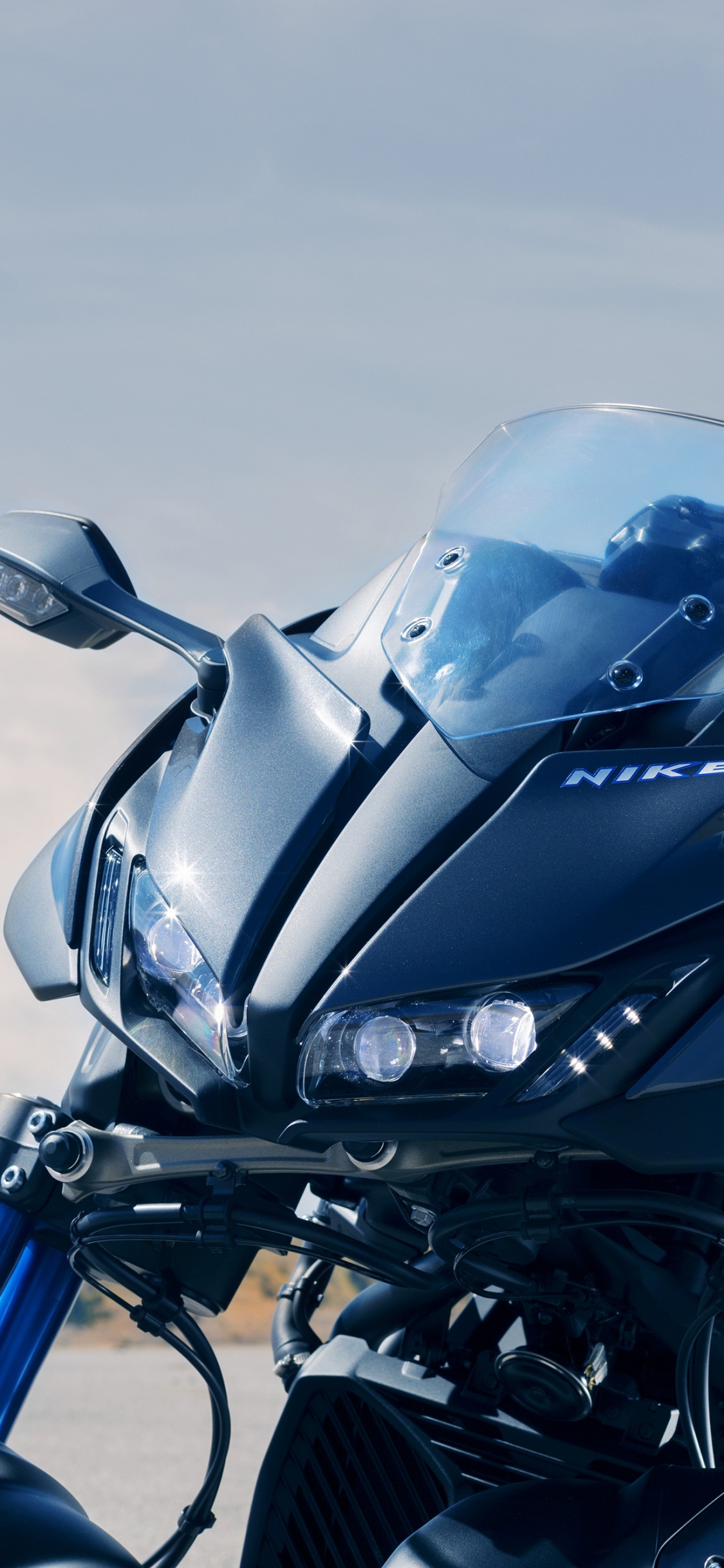 Moto Noire Sur Sable Brun. Wallpaper in 1125x2436 Resolution