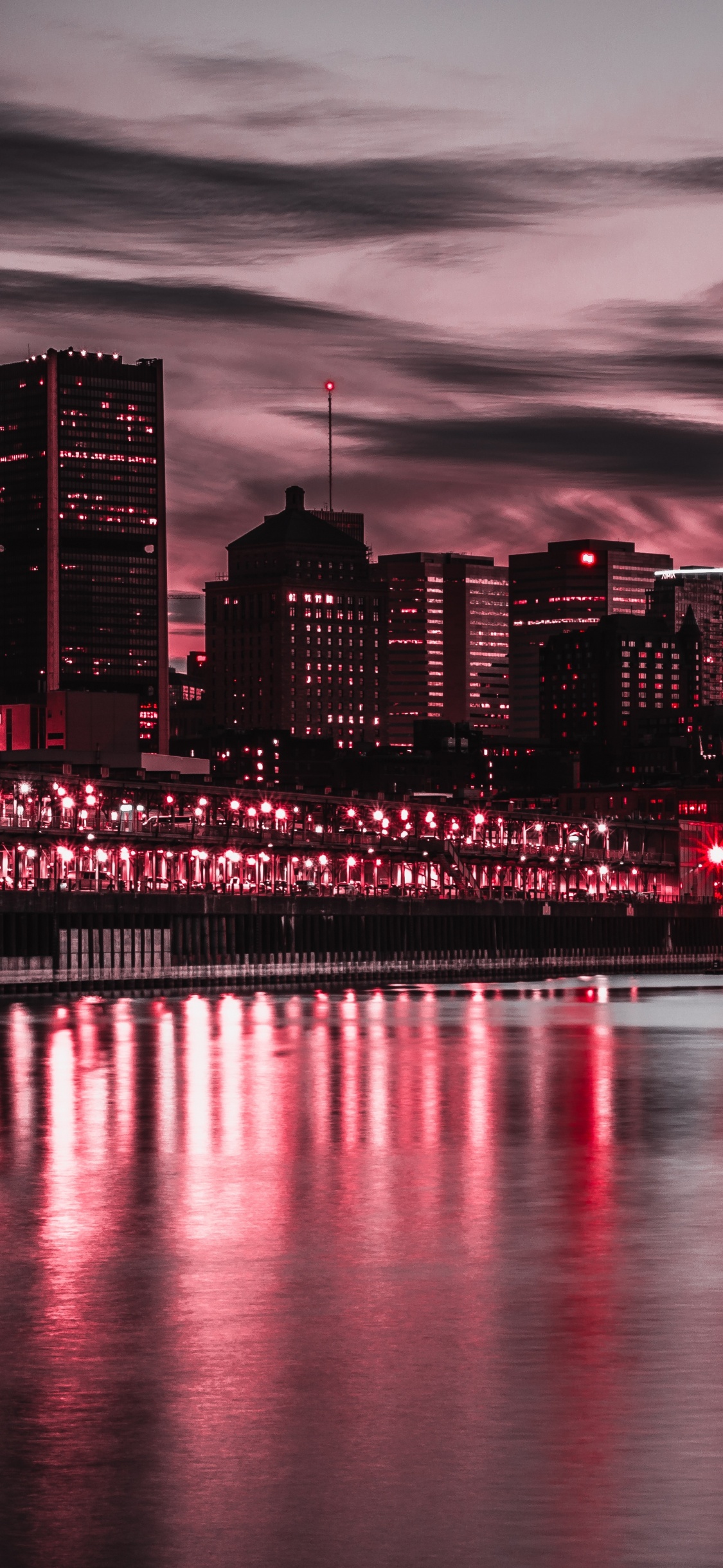 City Skyline Across Body of Water During Night Time. Wallpaper in 1125x2436 Resolution