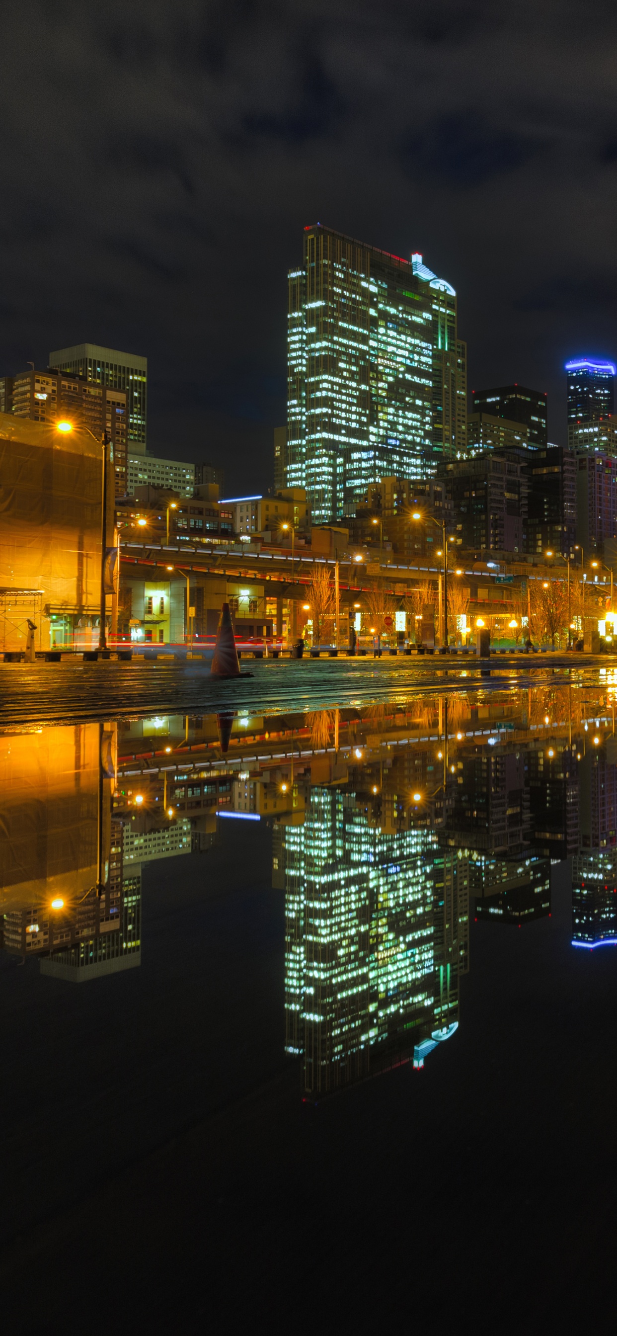 Horizonte de la Ciudad a Través Del Cuerpo de Agua Durante la Noche.. Wallpaper in 1242x2688 Resolution