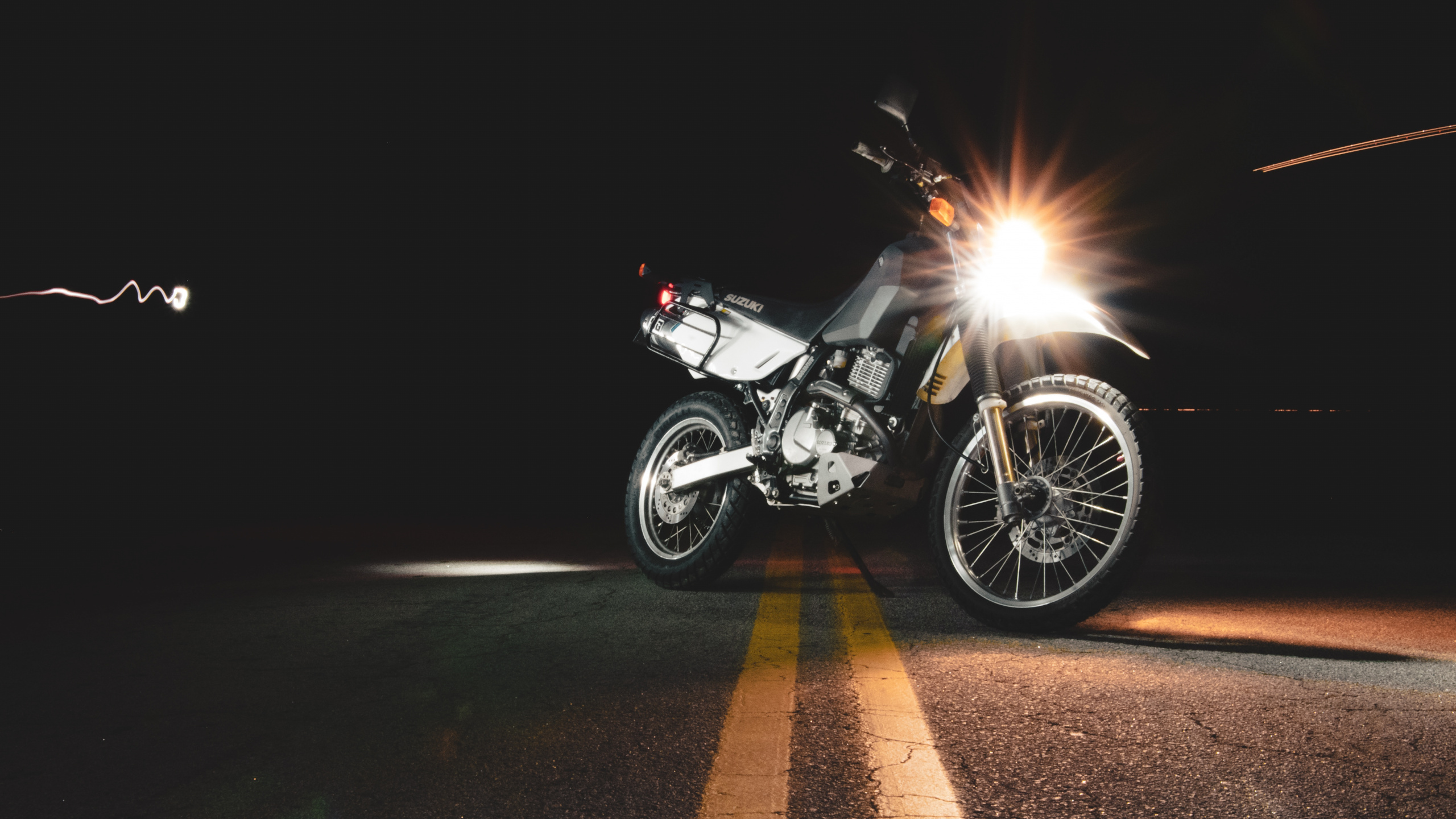 Schwarzes Und Silbernes Motorrad Unterwegs Während Der Nacht. Wallpaper in 2560x1440 Resolution