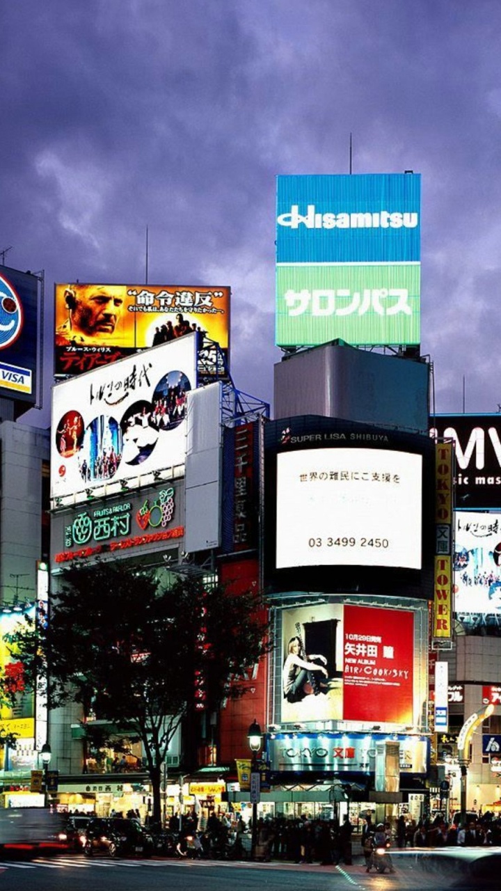 Calle de la Ciudad Con Coches Que Pasan Durante la Noche.. Wallpaper in 720x1280 Resolution