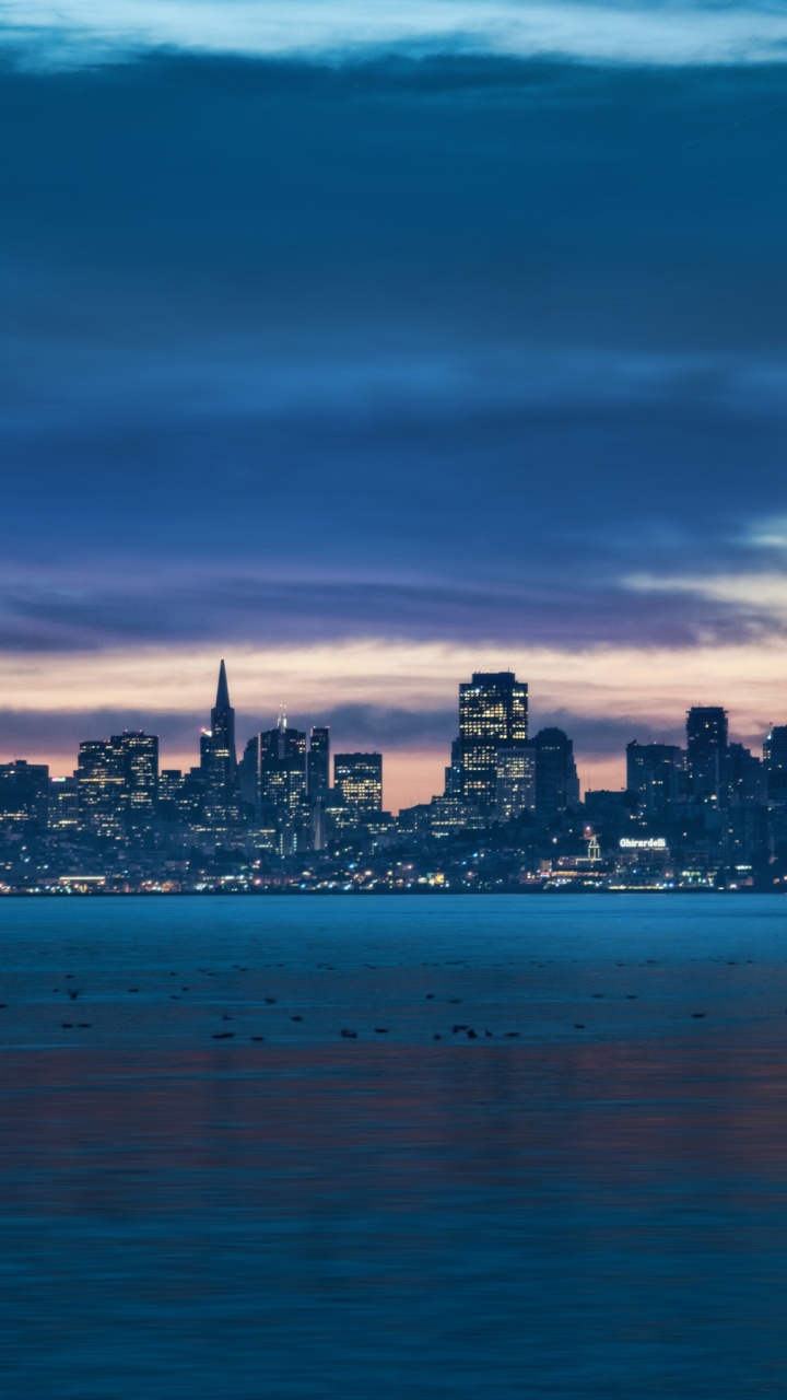 City Skyline Across Body of Water During Night Time. Wallpaper in 720x1280 Resolution