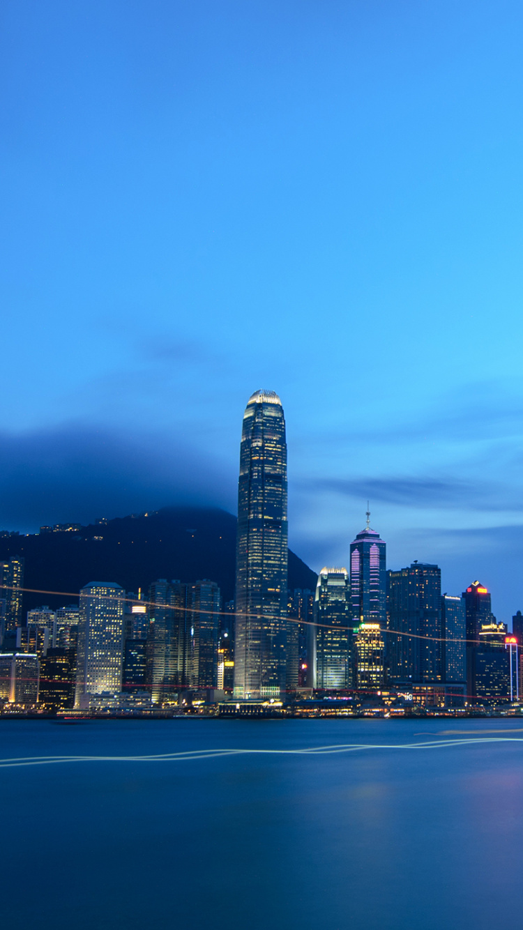 Horizonte de la Ciudad a Través Del Cuerpo de Agua Durante la Noche.. Wallpaper in 750x1334 Resolution