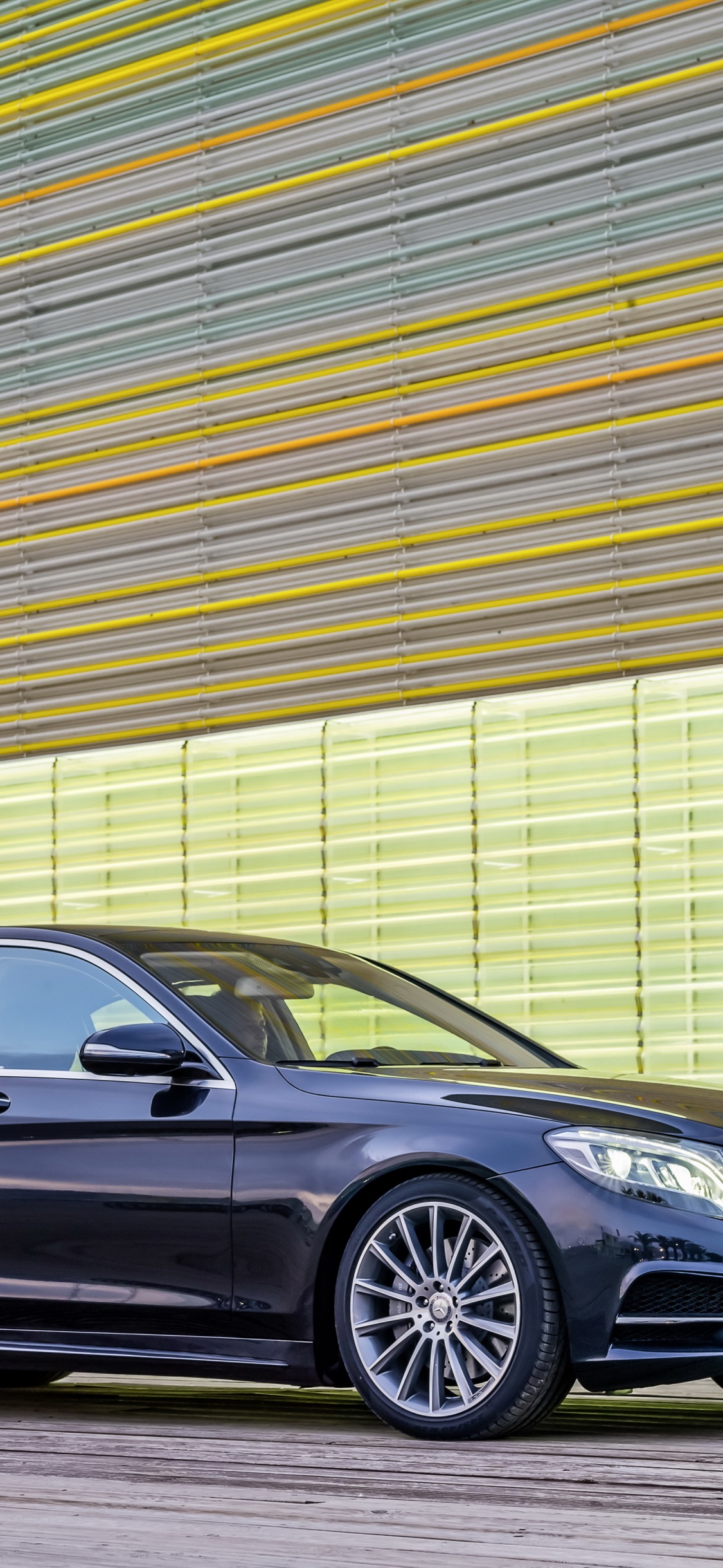 Black Mercedes Benz Coupe Parked Beside Brown Wall. Wallpaper in 1125x2436 Resolution