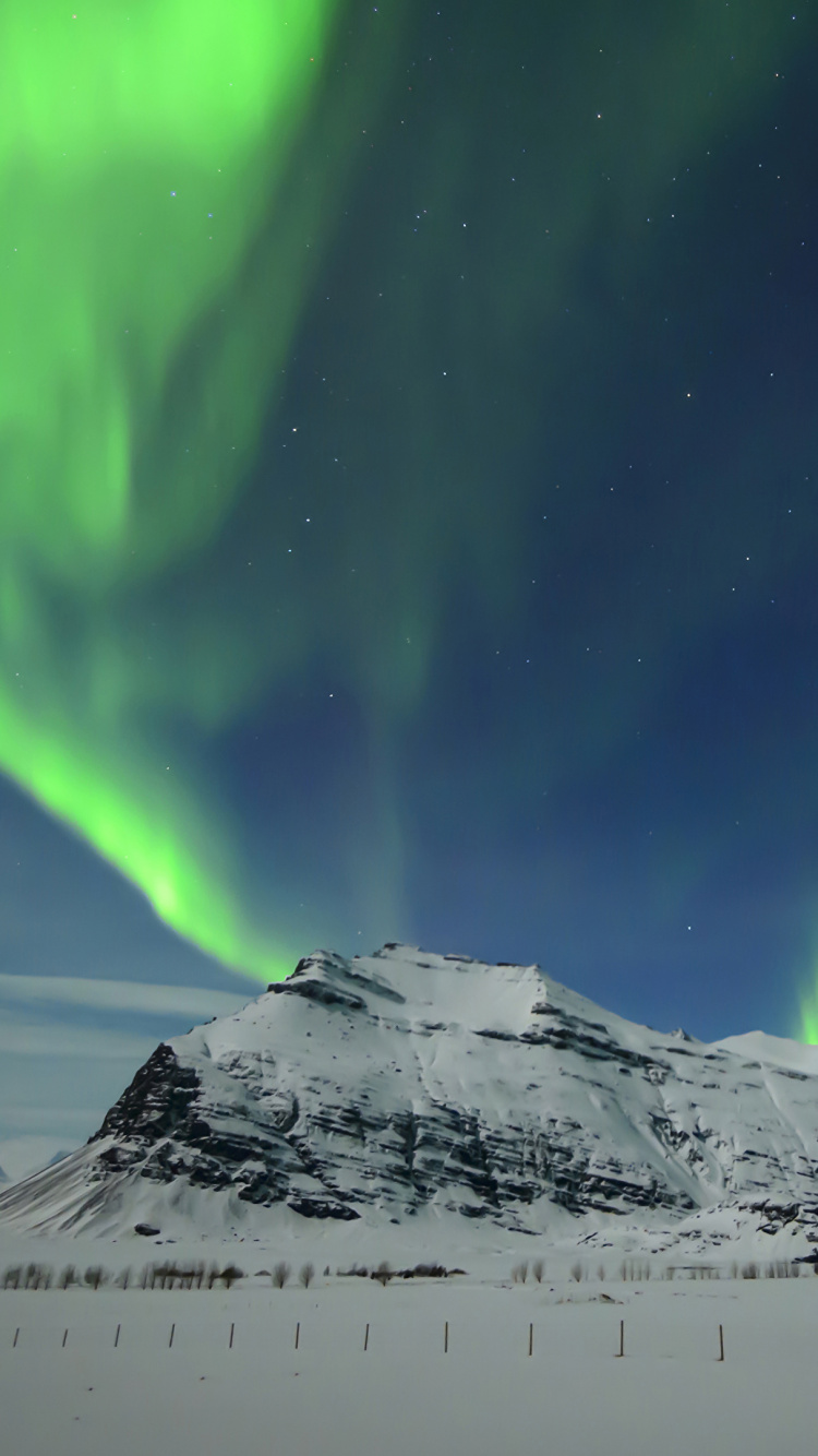 Snow Covered Mountain Under Green Sky. Wallpaper in 750x1334 Resolution