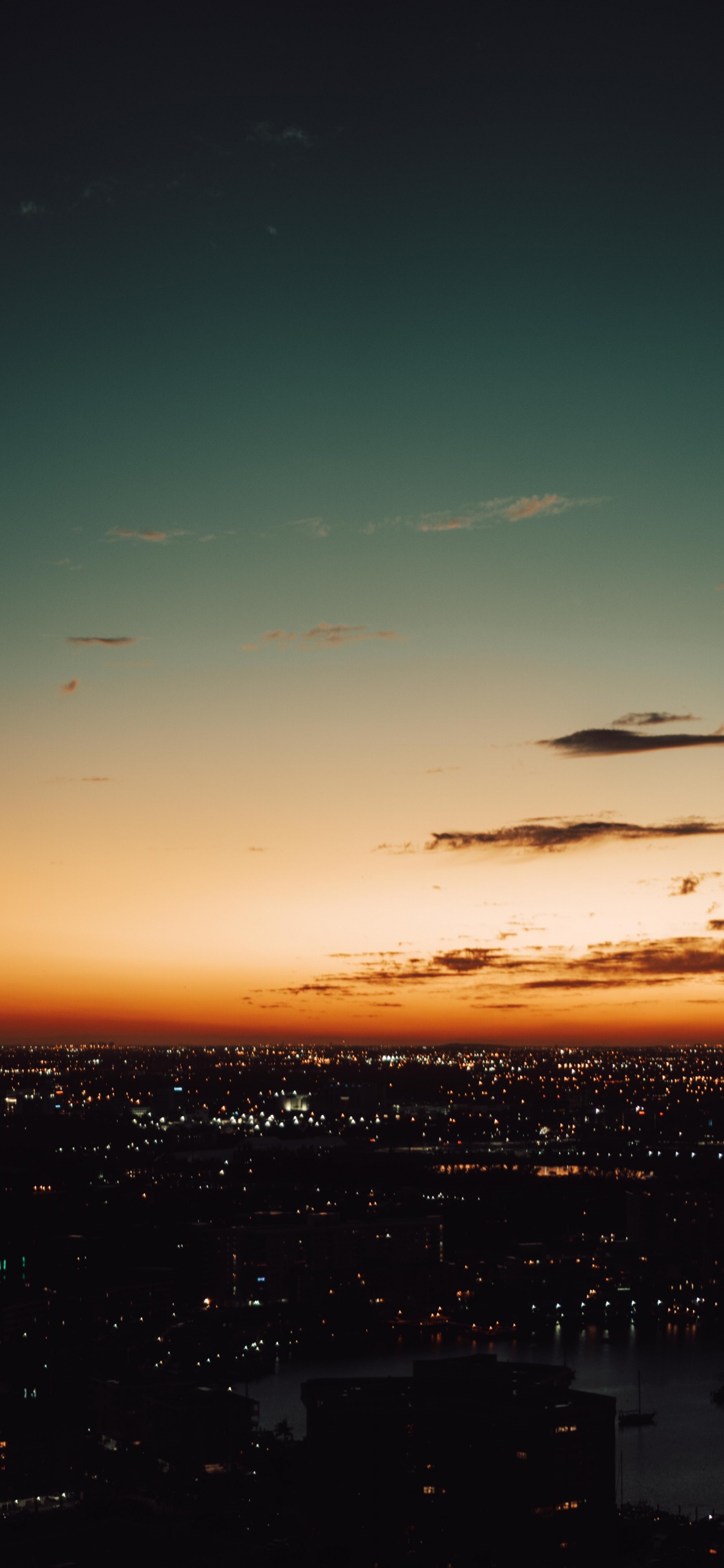 Silhouette Von Stadtgebäuden Bei Sonnenuntergang. Wallpaper in 1125x2436 Resolution