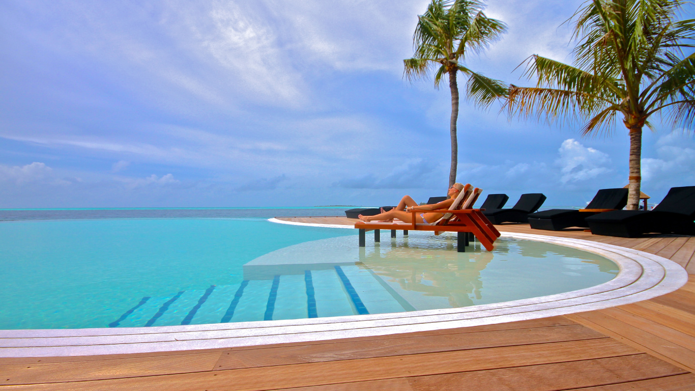 2 Brown Wooden Lounge Chairs on White Sand Beach During Daytime. Wallpaper in 1366x768 Resolution