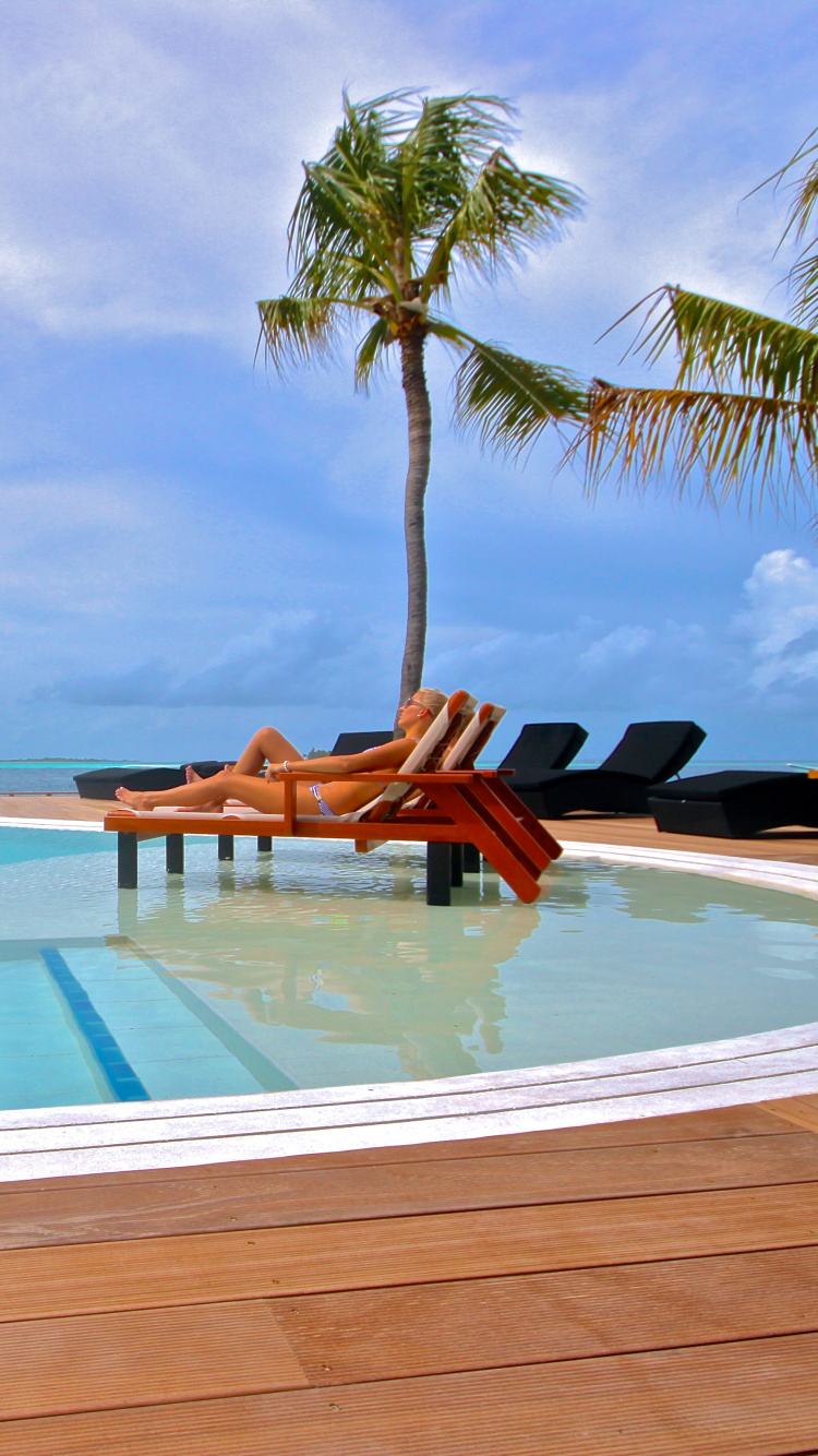 2 Brown Wooden Lounge Chairs on White Sand Beach During Daytime. Wallpaper in 750x1334 Resolution