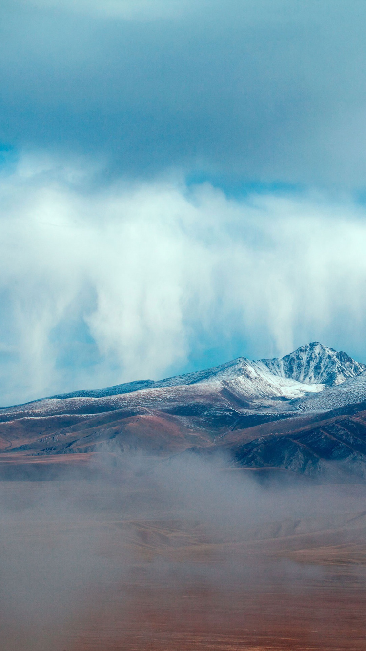 Snow Covered Mountain Under Cloudy Sky During Daytime. Wallpaper in 750x1334 Resolution