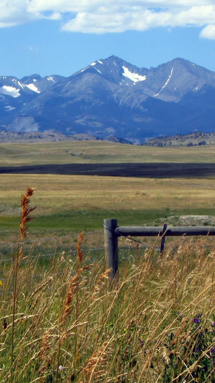 Brown Wooden Fence on Green Grass Field Near Mountains During Daytime. Wallpaper in 720x1280 Resolution