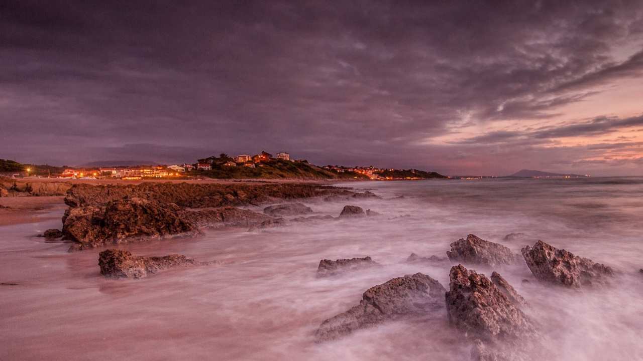 Les Vagues de L'océan S'écrasent Sur Les Rochers Sous Les Nuages Gris. Wallpaper in 1280x720 Resolution