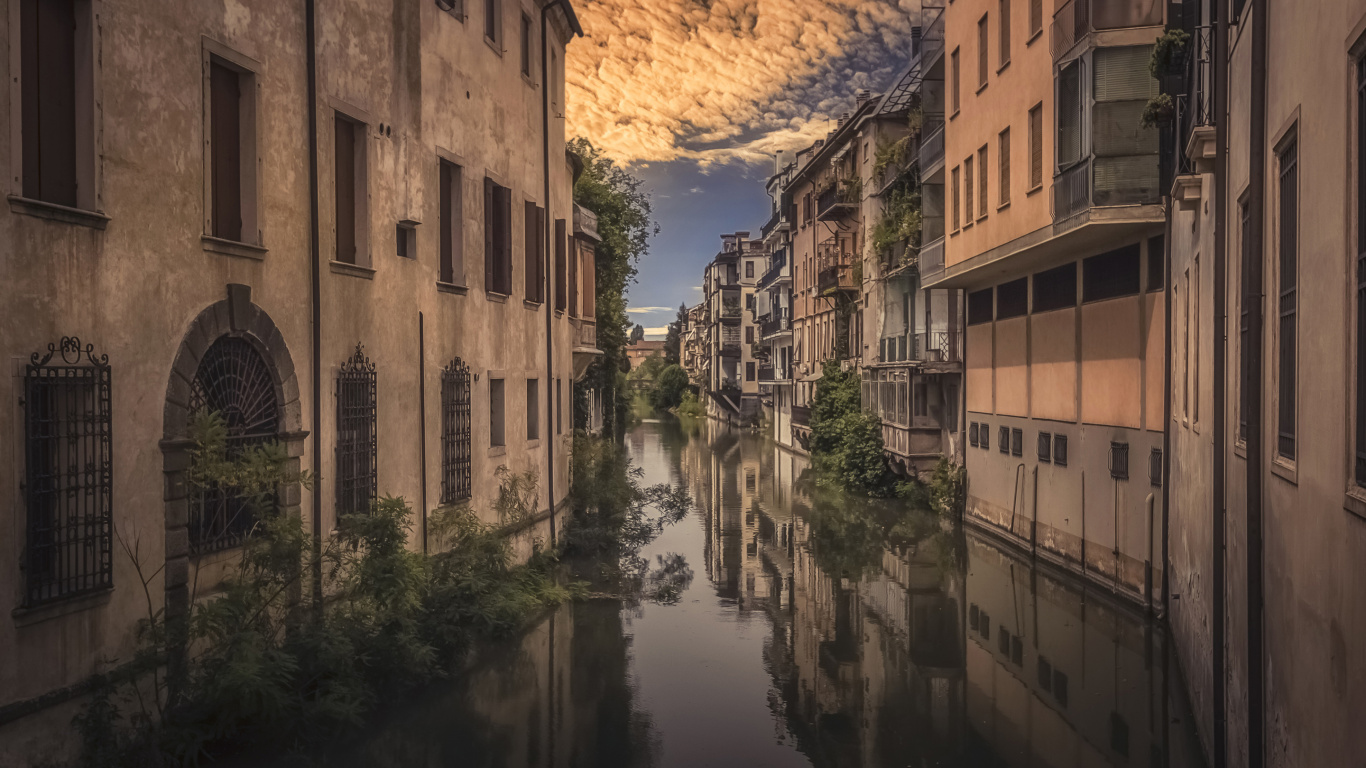 Brown Concrete Building Beside River During Daytime. Wallpaper in 1366x768 Resolution