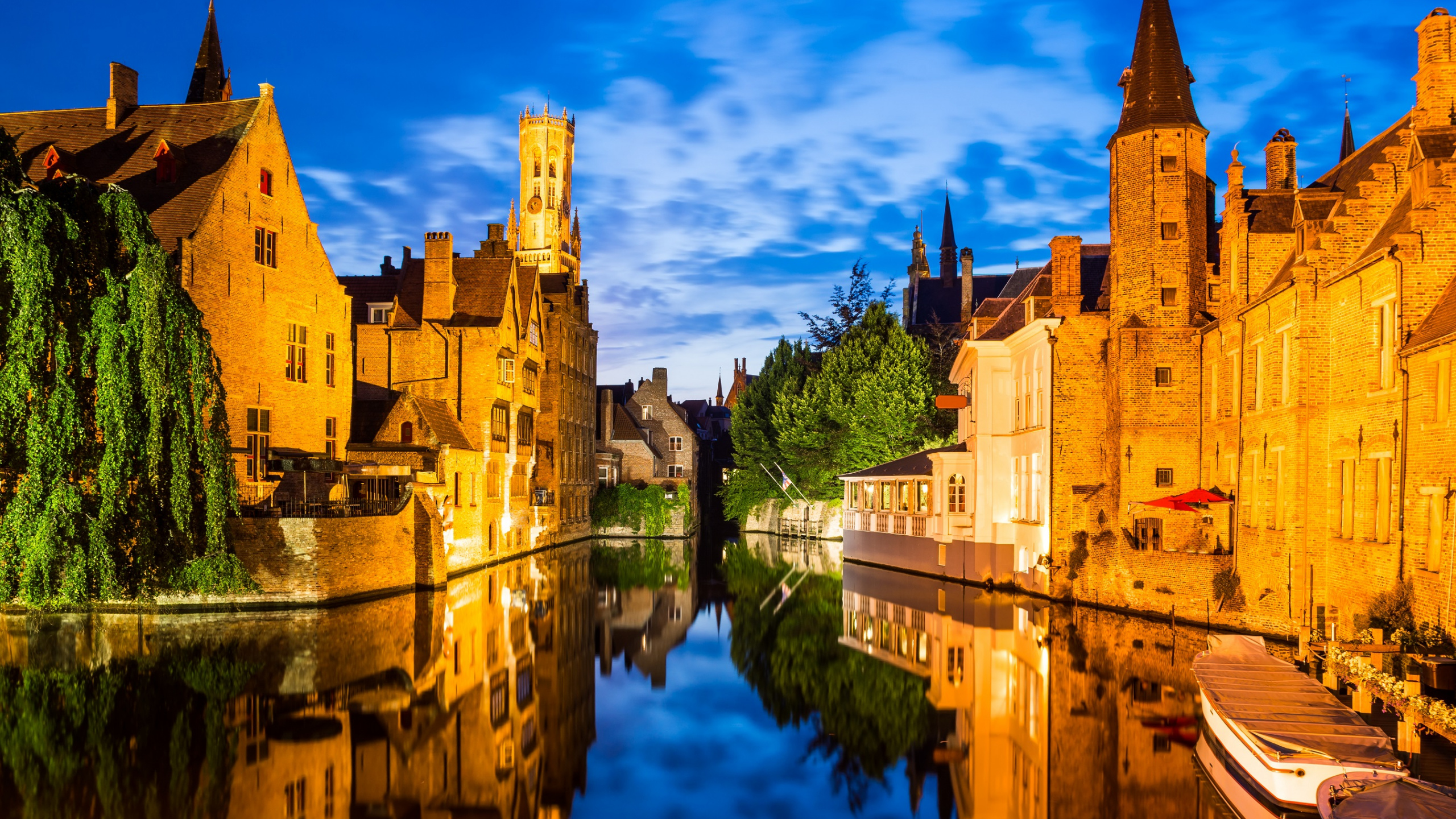 Braunes Betongebäude Neben Gewässer Unter Blauem Himmel Tagsüber. Wallpaper in 2560x1440 Resolution