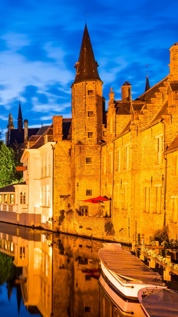 Braunes Betongebäude Neben Gewässer Unter Blauem Himmel Tagsüber. Wallpaper in 720x1280 Resolution