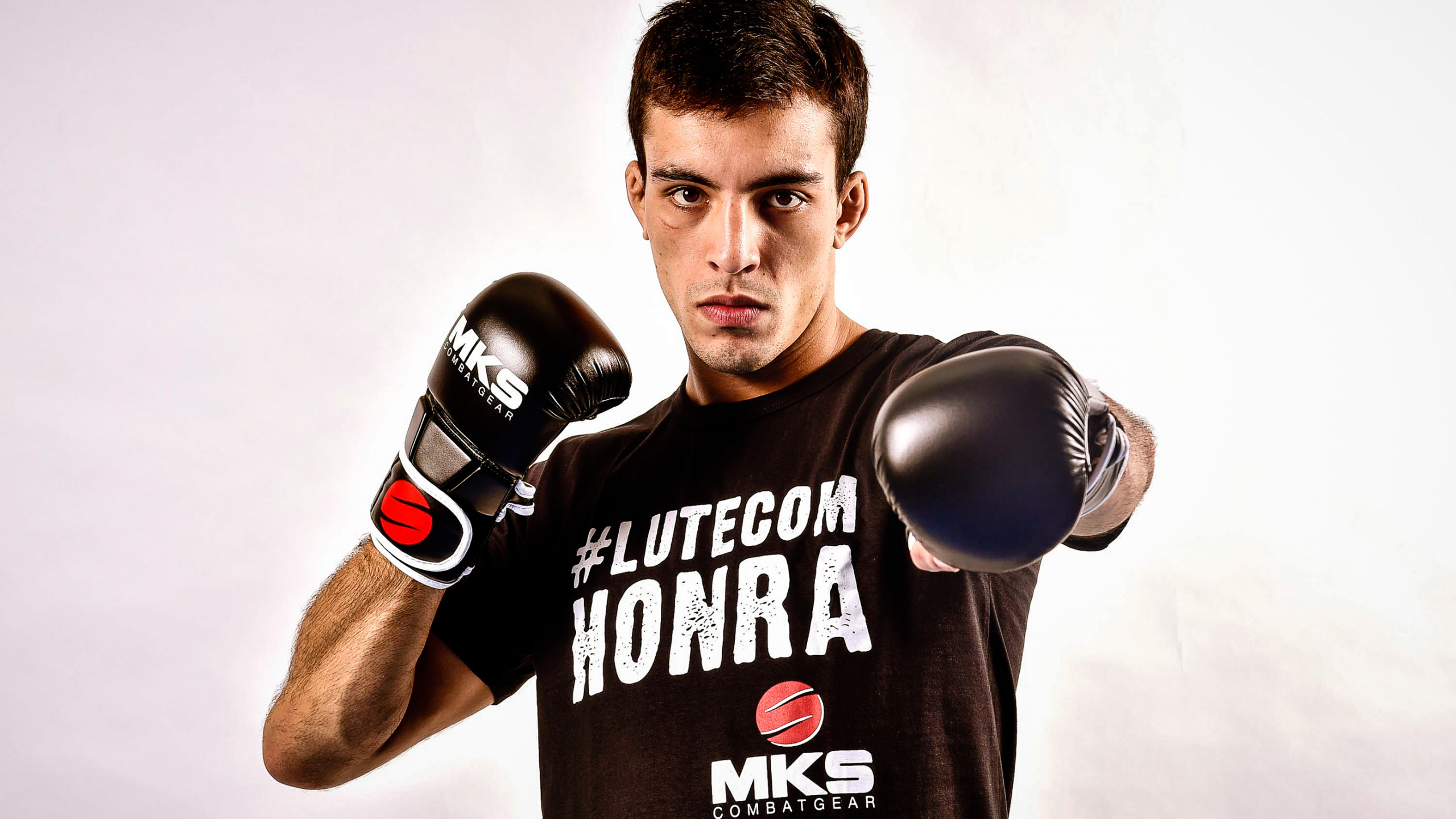 Man in Black and White Crew Neck T-shirt Wearing Black Boxing Gloves. Wallpaper in 2560x1440 Resolution