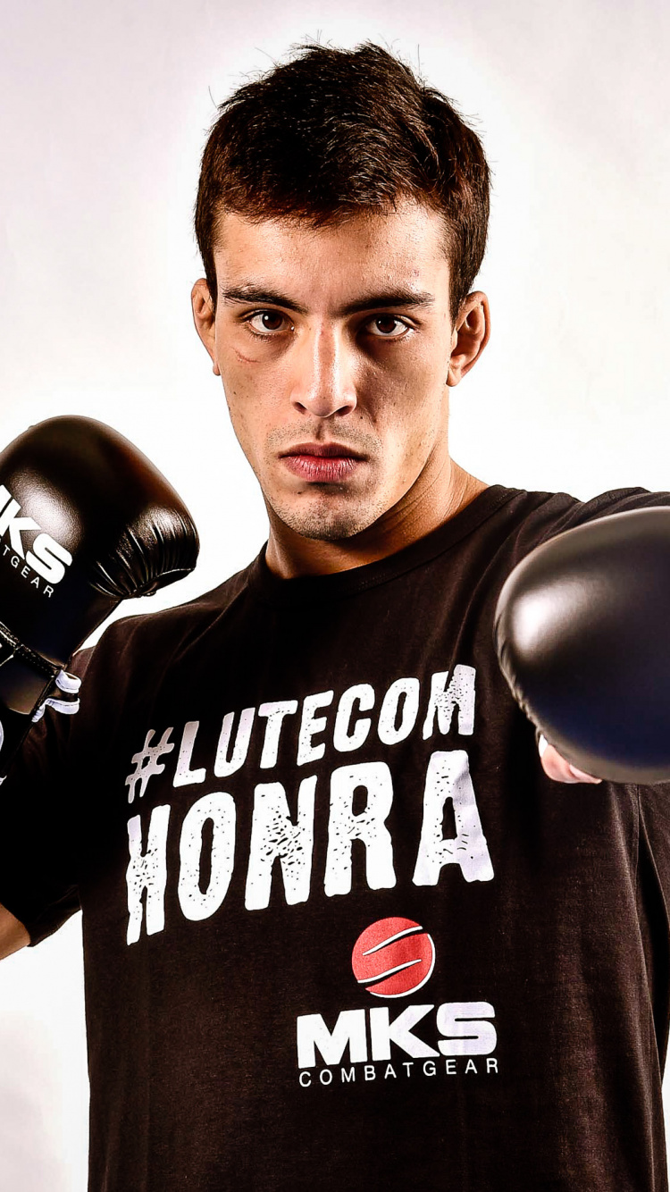 Man in Black and White Crew Neck T-shirt Wearing Black Boxing Gloves. Wallpaper in 750x1334 Resolution