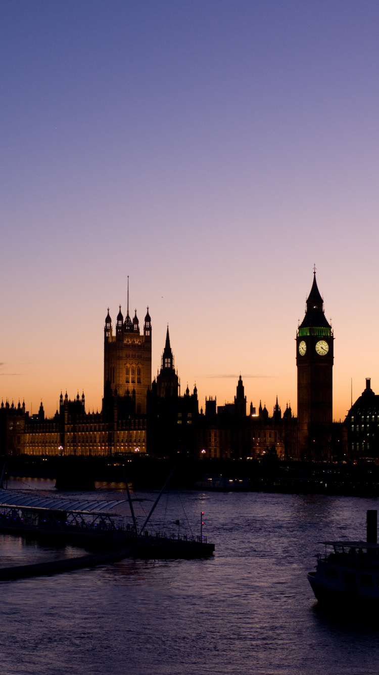 Brown Concrete Building Near Body of Water During Daytime. Wallpaper in 750x1334 Resolution