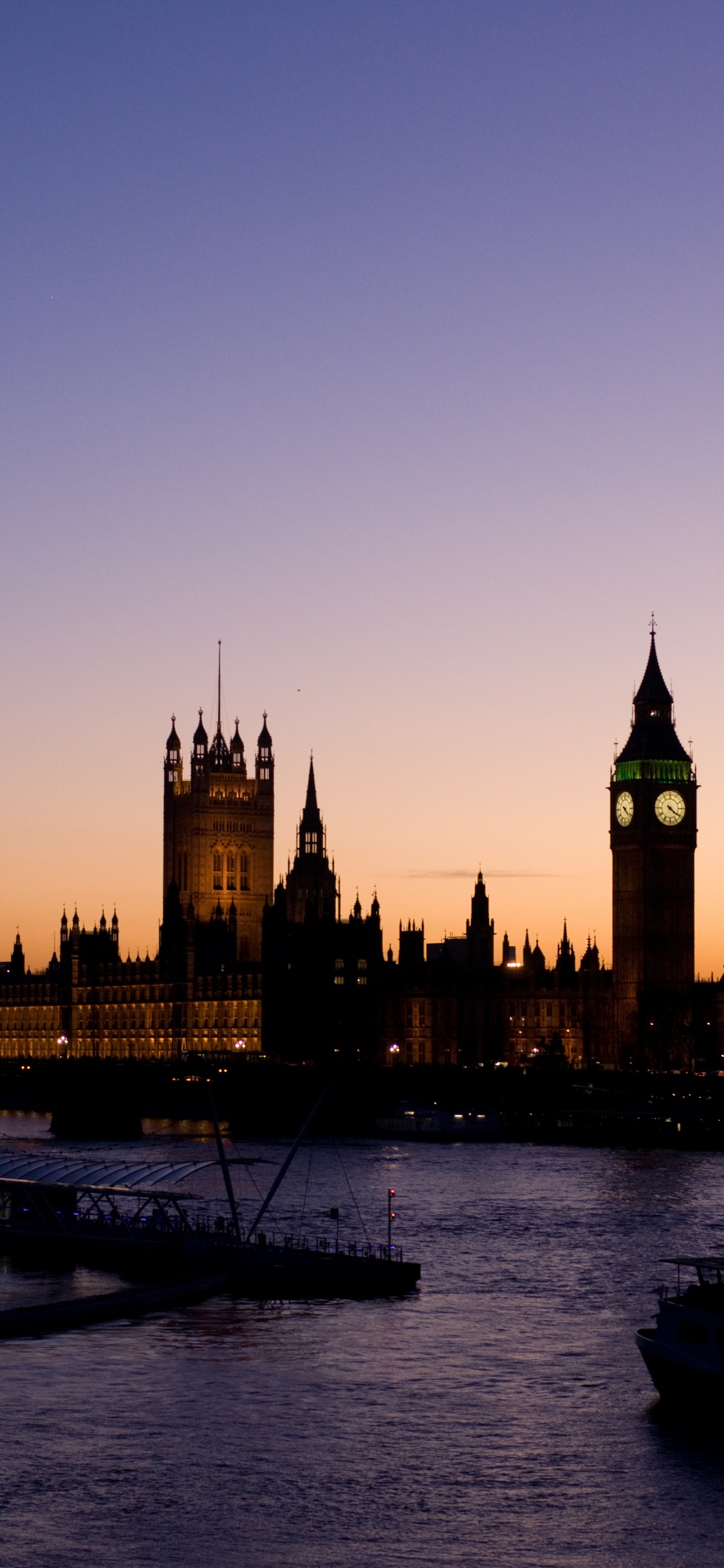 Bâtiment en Béton Brun Près D'un Plan D'eau Pendant la Journée. Wallpaper in 1125x2436 Resolution