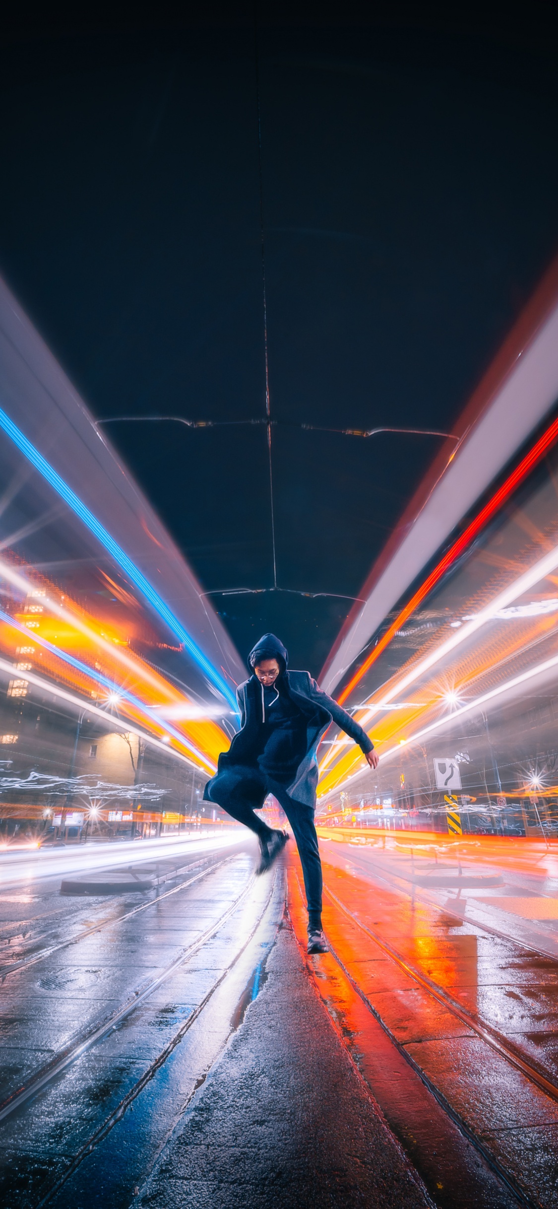 Man in Black Jacket and Black Pants Walking on Street During Night Time. Wallpaper in 1125x2436 Resolution