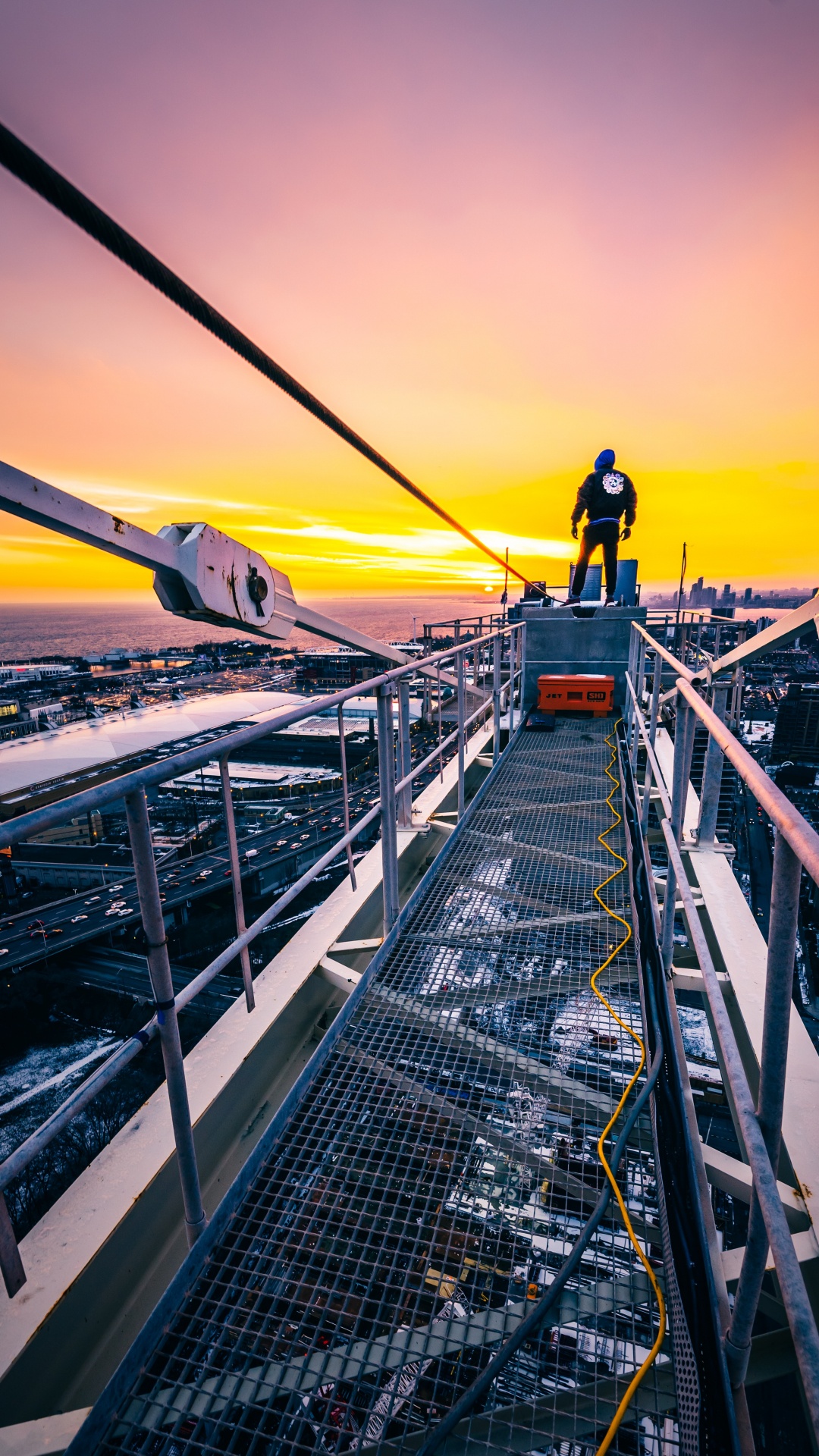 Man in Black Jacket and Black Pants Standing on Top of The Building During Sunset. Wallpaper in 1080x1920 Resolution
