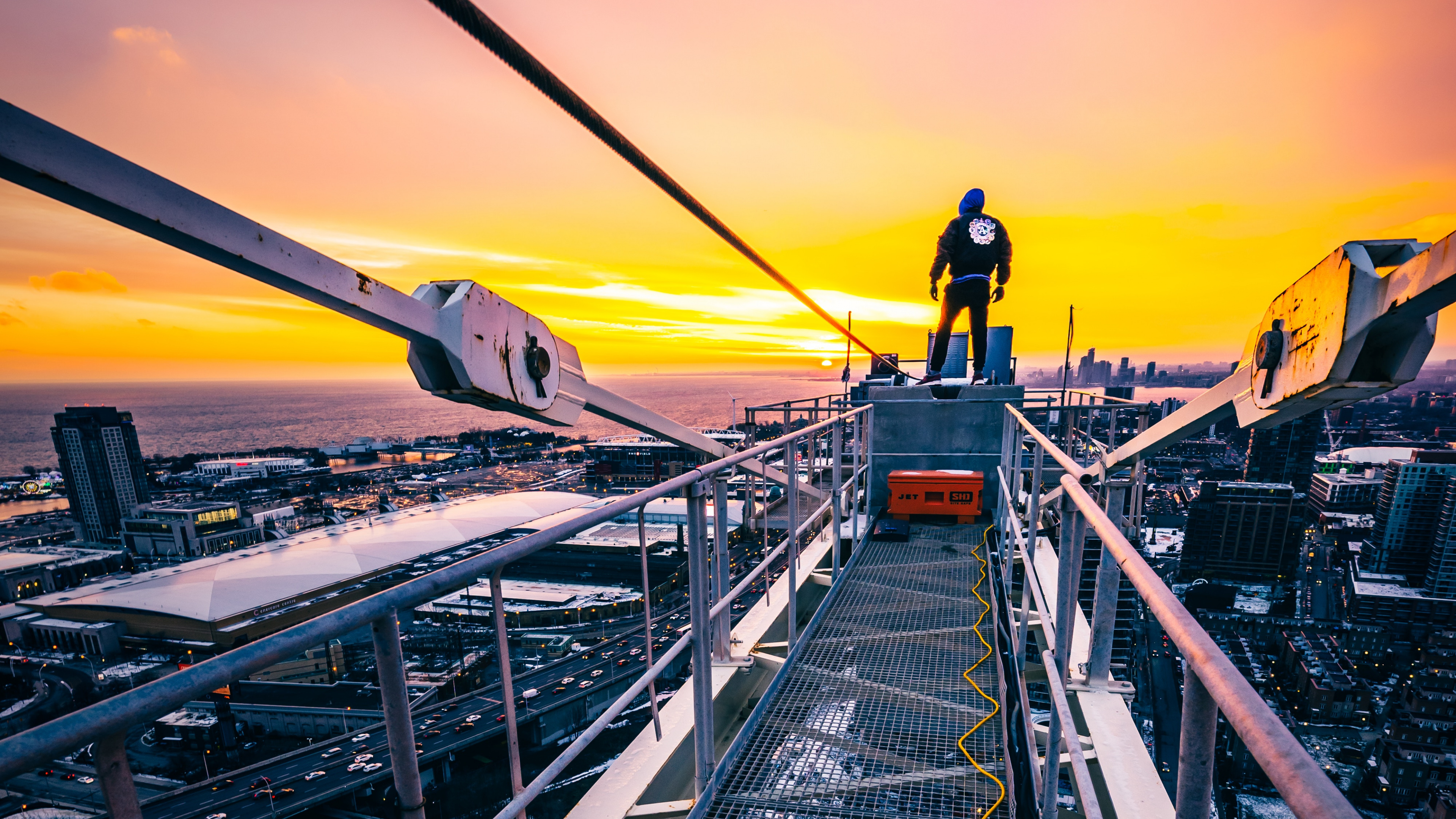 Man in Black Jacket and Black Pants Standing on Top of The Building During Sunset. Wallpaper in 3840x2160 Resolution