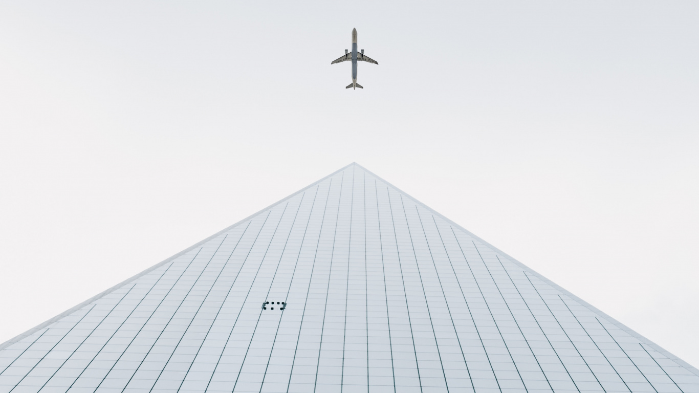 Airplane Flying Over The Building. Wallpaper in 1366x768 Resolution