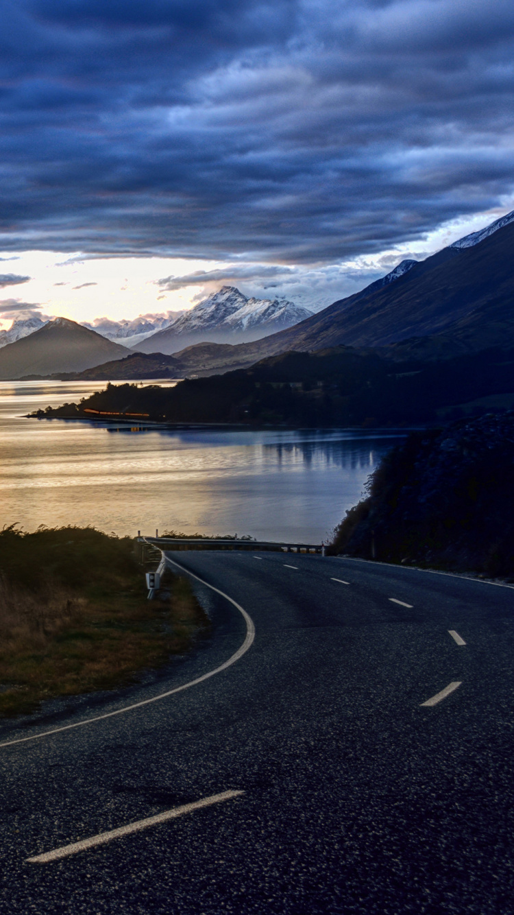 Gray Concrete Road Near Lake Under White Clouds and Blue Sky During Daytime. Wallpaper in 750x1334 Resolution