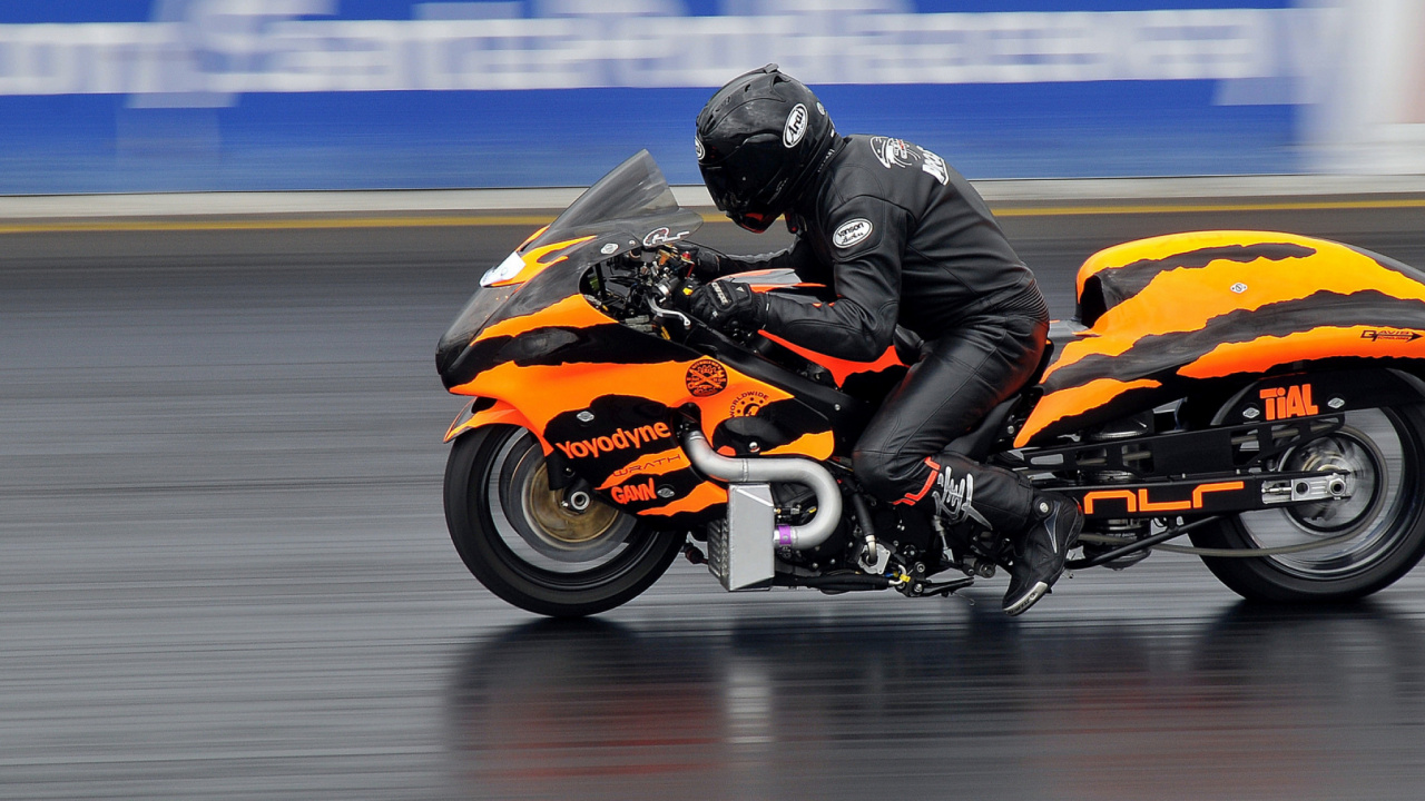 Man in Black Jacket Riding Orange Sports Bike. Wallpaper in 1280x720 Resolution