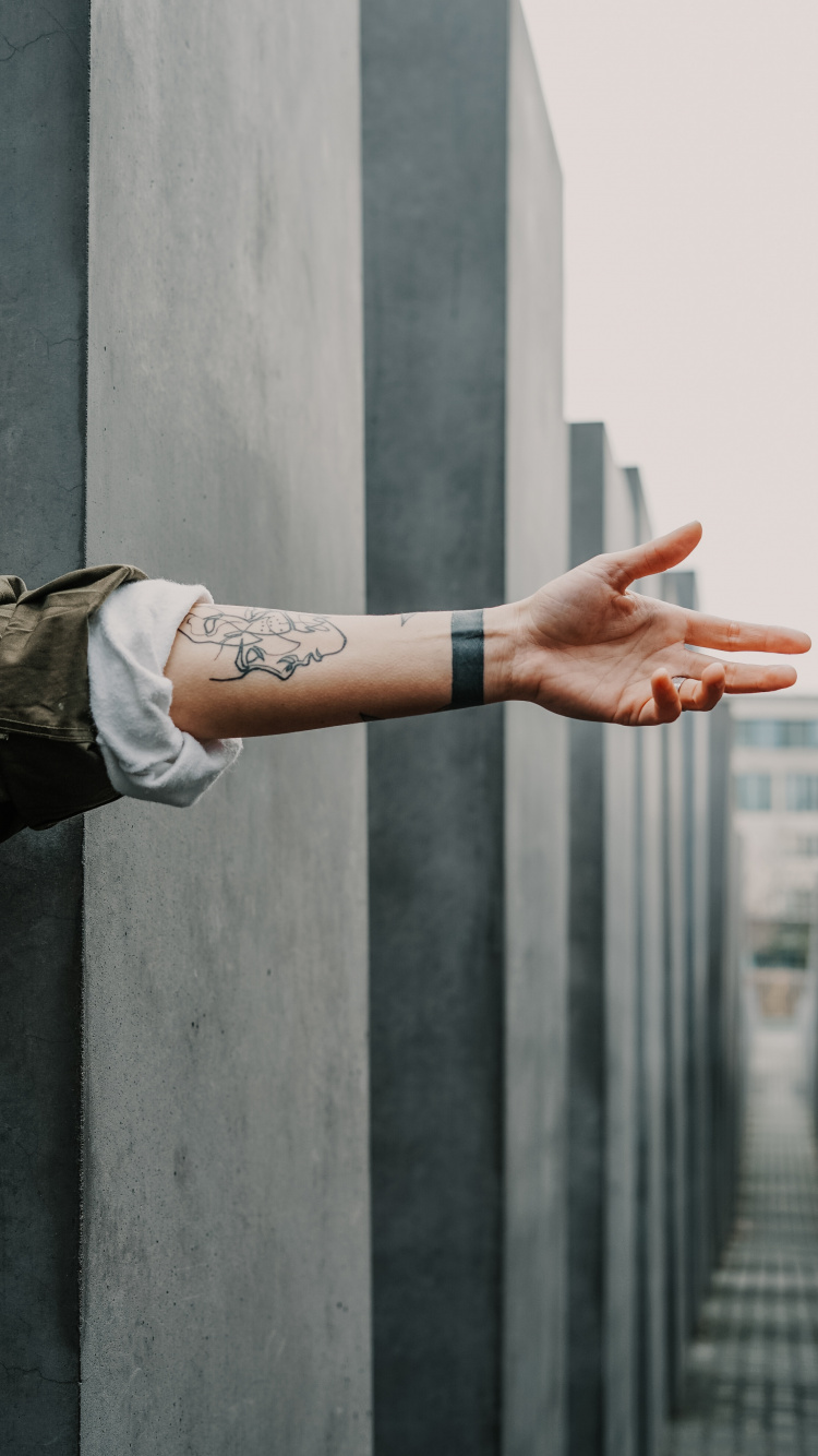 Persona en Camisa de Manga Larga Marrón Con Reloj de Correa de Cuero Marrón. Wallpaper in 750x1334 Resolution
