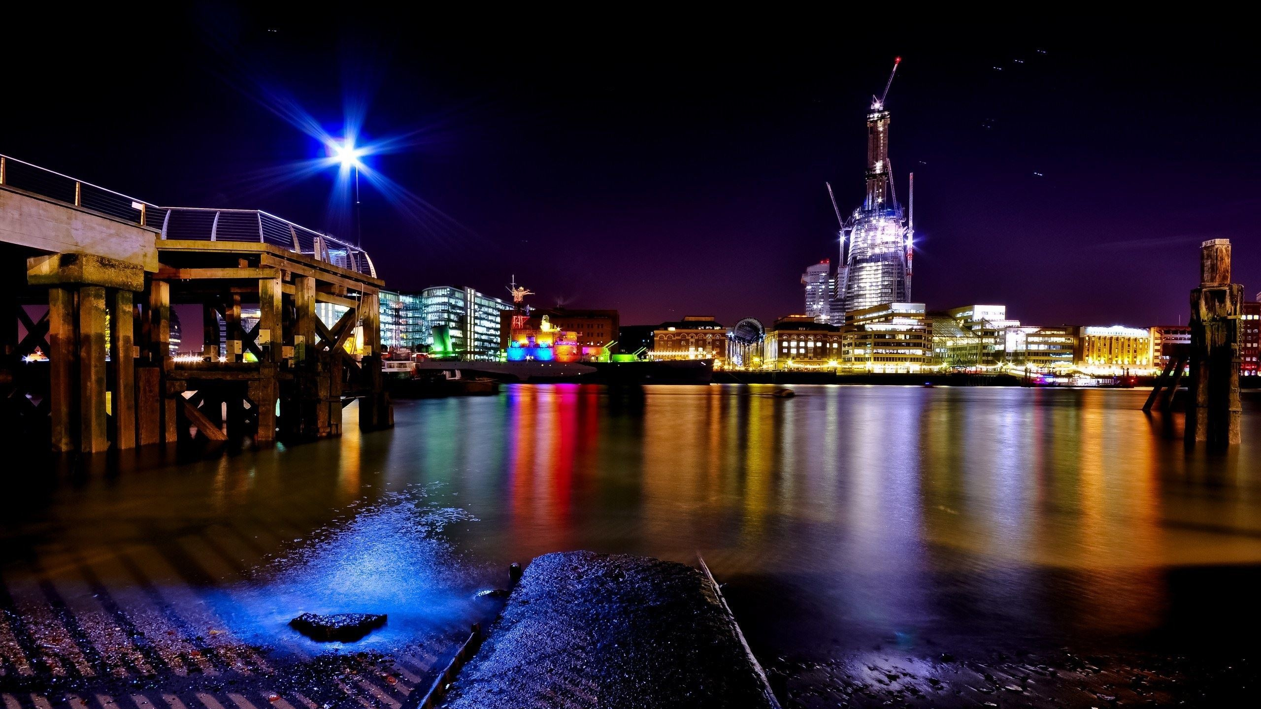 Cuerpo de Agua Cerca de Los Edificios de la Ciudad Durante la Noche. Wallpaper in 2560x1440 Resolution