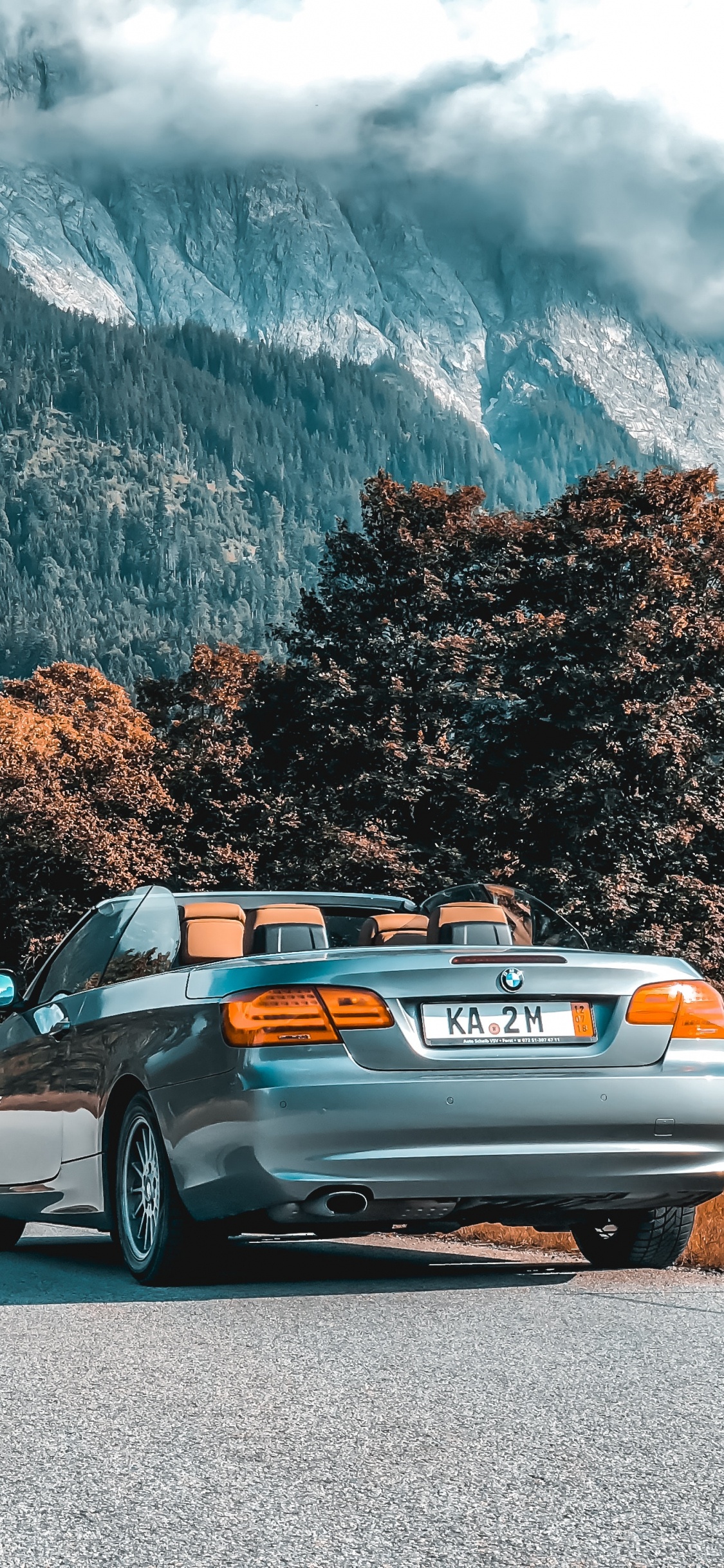 Silberne Limousine Auf Grauer Asphaltstraße Tagsüber. Wallpaper in 1125x2436 Resolution