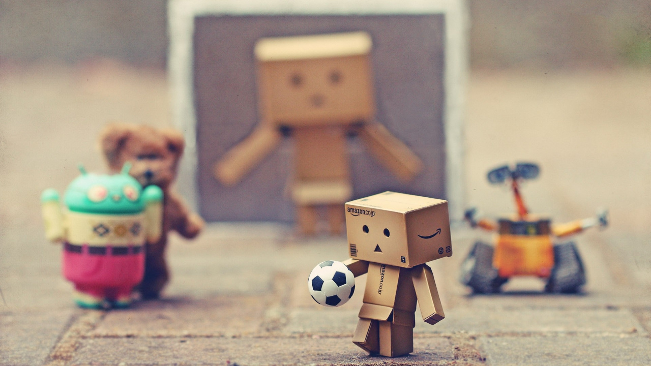 Robot en Carton Marron Tenant un Ballon de Football. Wallpaper in 1280x720 Resolution