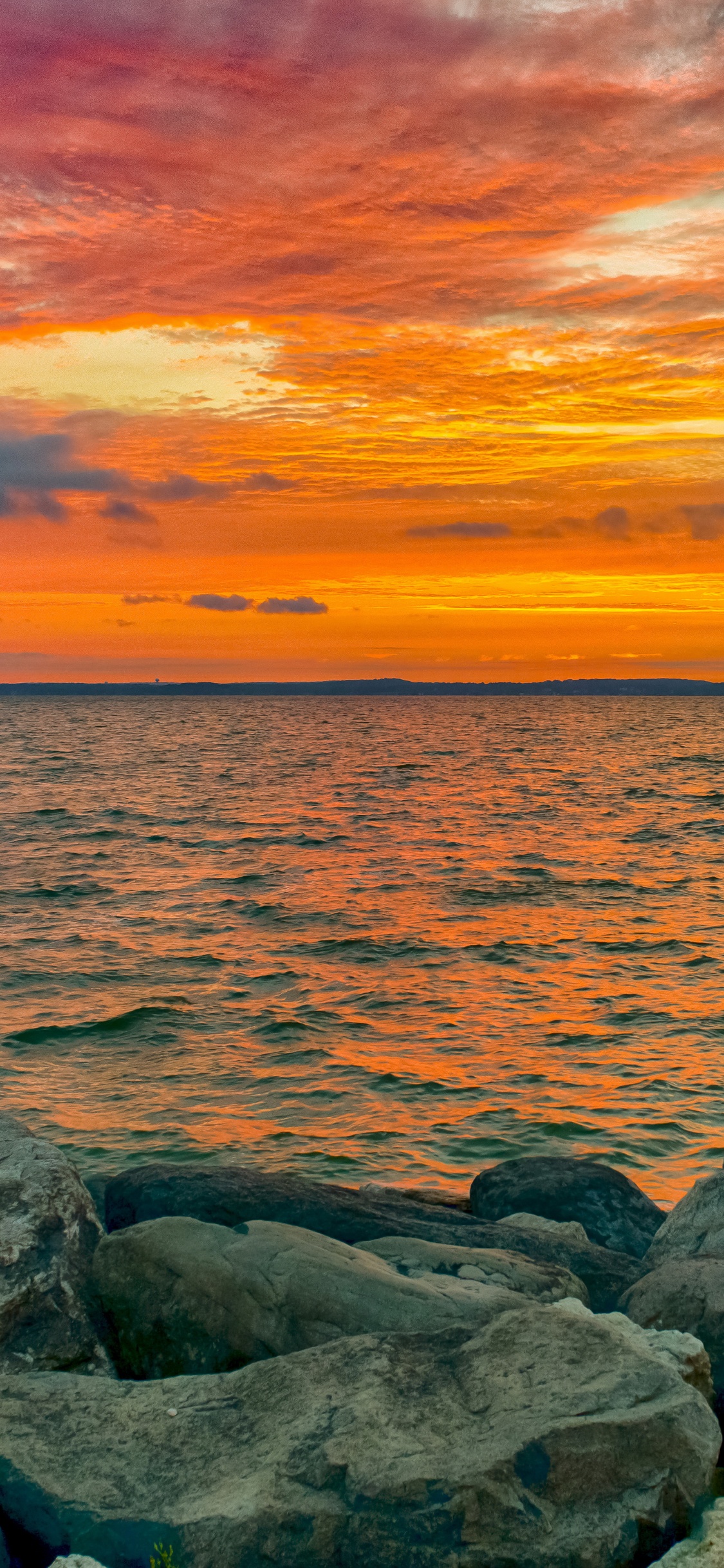 Graue Felsen am Meer Bei Sonnenuntergang. Wallpaper in 1125x2436 Resolution